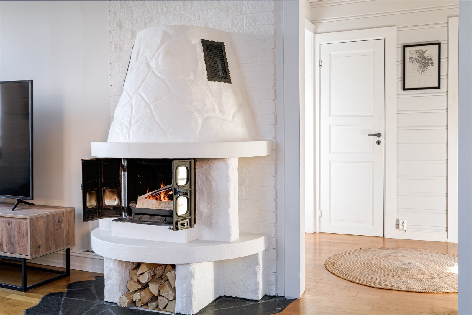 Hyggelig vedovn i stuen tilfører leiligheten varme på kalde vinterdager. Galleribilde