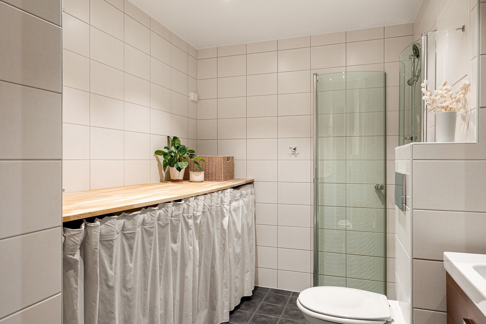 Badet består av dusj, toalett, servant med underskap og opplegg/plass til vaskemaskin. Galleribilde