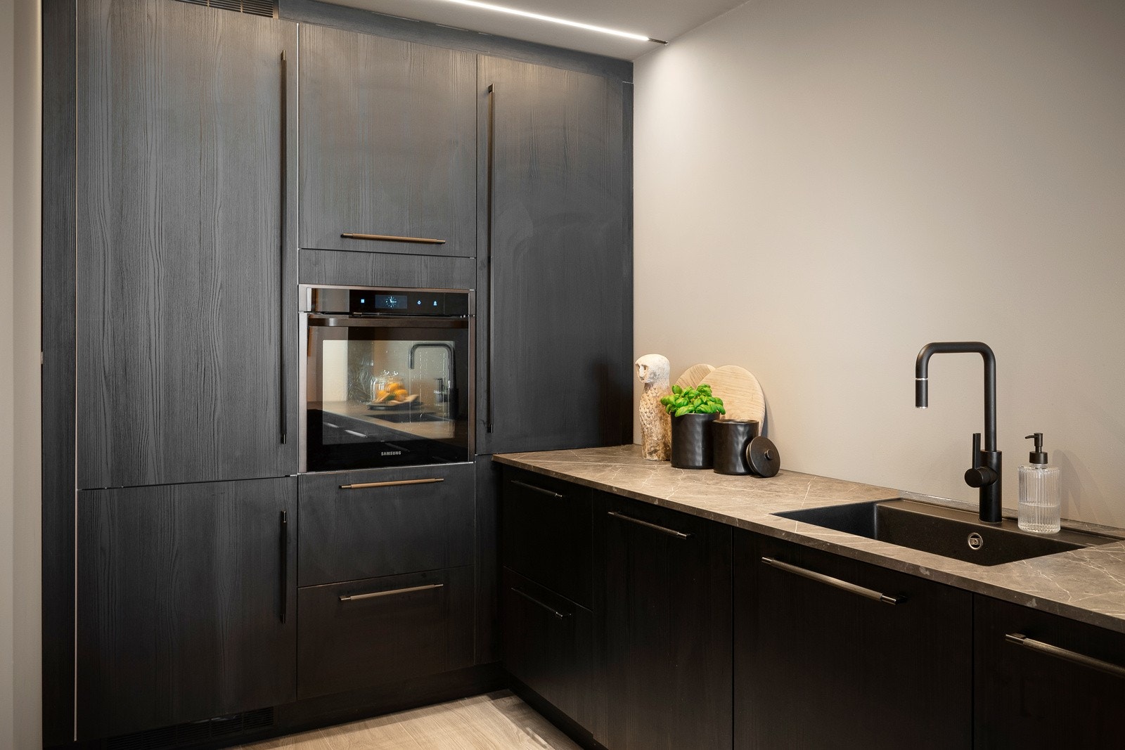 Innredningen på kjøkkenet består av laminert benkeplate med integrert kjøkkenkum, oppvaskmaskin, komfyr, platetopp og kjøl/frys Galleribilde