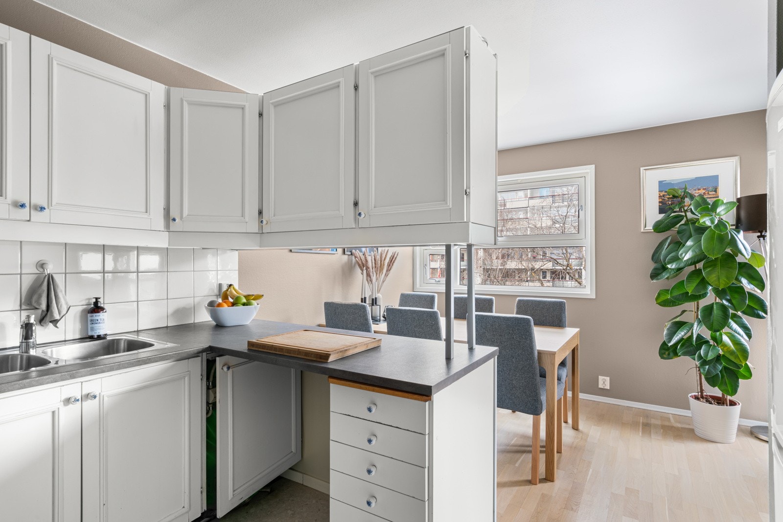 Kjøkkenet består blant annet av profilerte fronter, fliser på vegg over benkeskap, laminert benkeplate og opplegg for oppvaskmaskin. Galleribilde