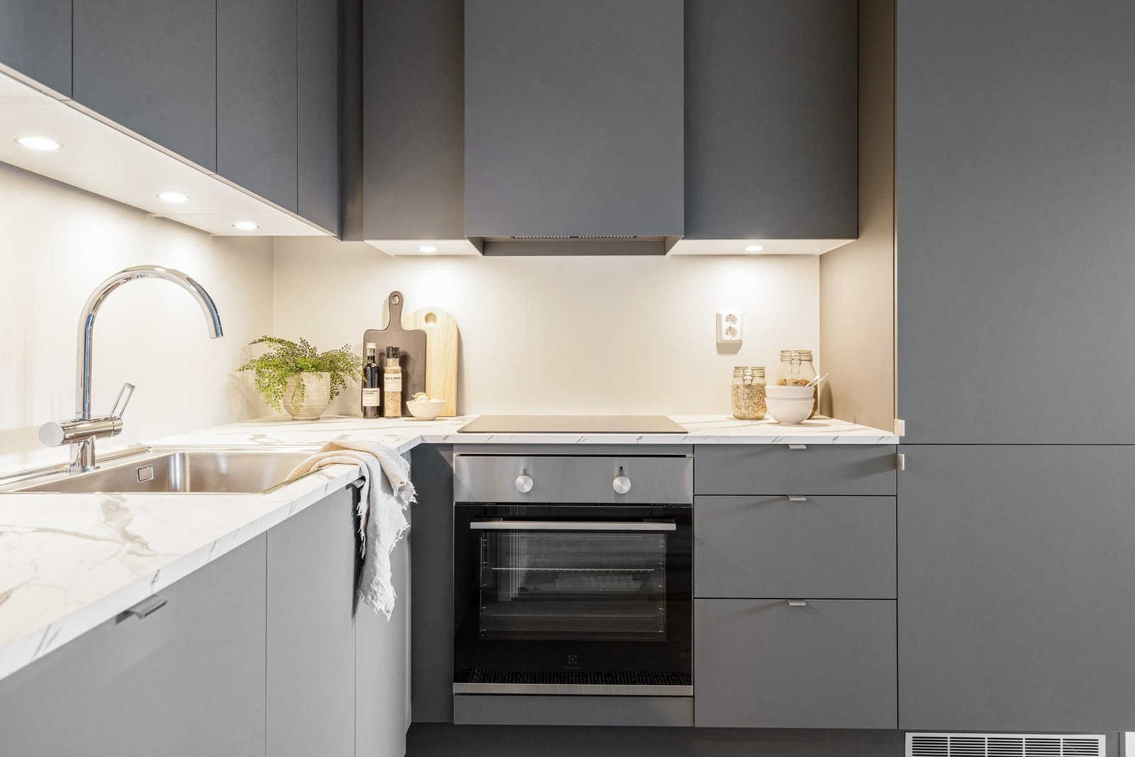 Ventilator (Røroshetta Mantica vegghengt). Grepsløse overskap. Innfelte downlights i overskap. Nedforing fra himling til overskap. Galleribilde