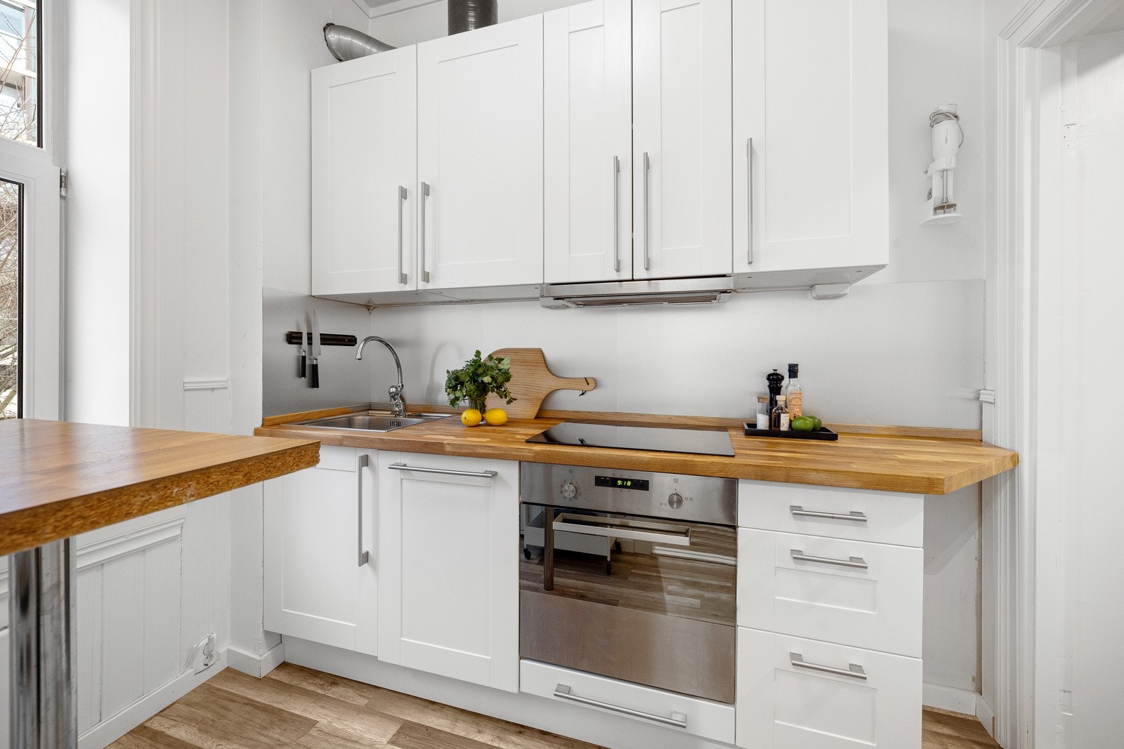 Stilrent kjøkken med glatte fronter, nedfelt oppvaskkum og heltre benkeplate fra 2019, pusset og oljet i 2024. Galleribilde