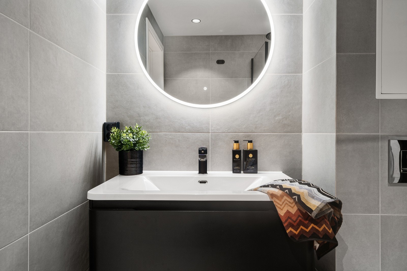 Badet ventileres med mekanisk avtrekk og har rør-i-rør system. Moderne speil med overlys og stikkontakt over servant. Galleribilde