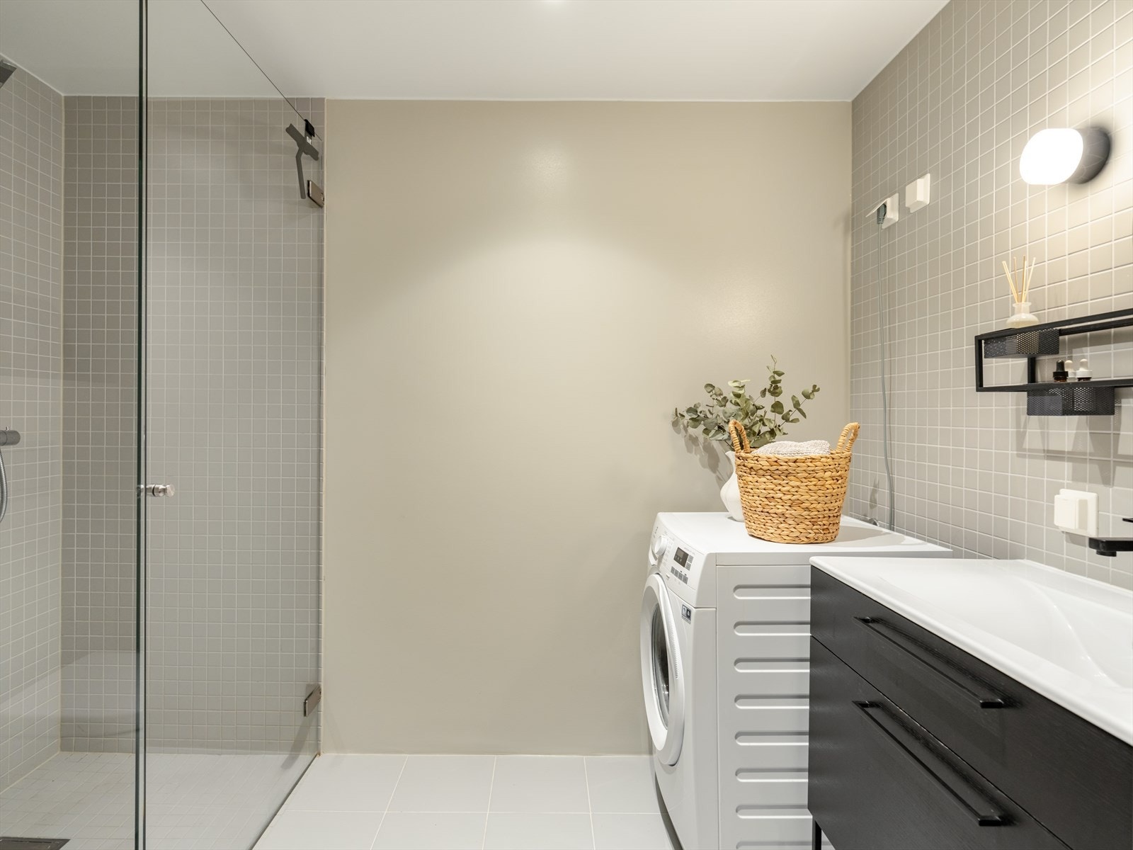 Fra entreen finner vi leilighetens baderom. Det er pent flislagt, med downlights i himling og varme i gulv. Galleribilde