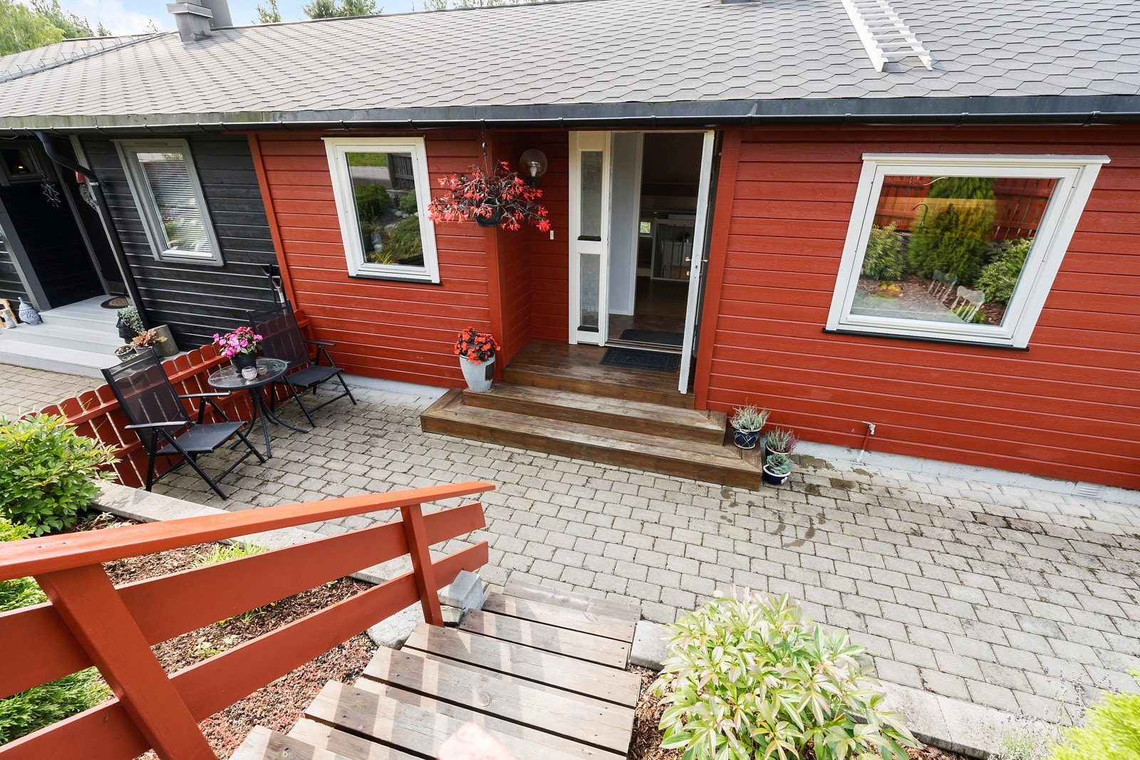 Pent opparbeid og steinbelagt inngangsparti med velstelt blomsterbed Galleribilde