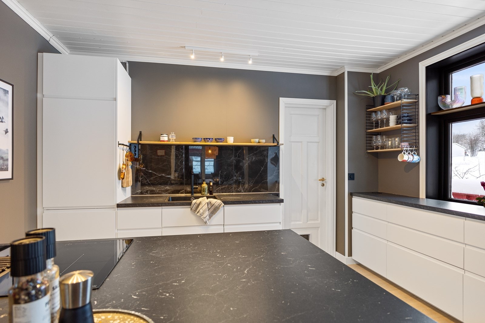 Innenfor kjøkkenet er det spisskammer med dør ut til hagen Galleribilde