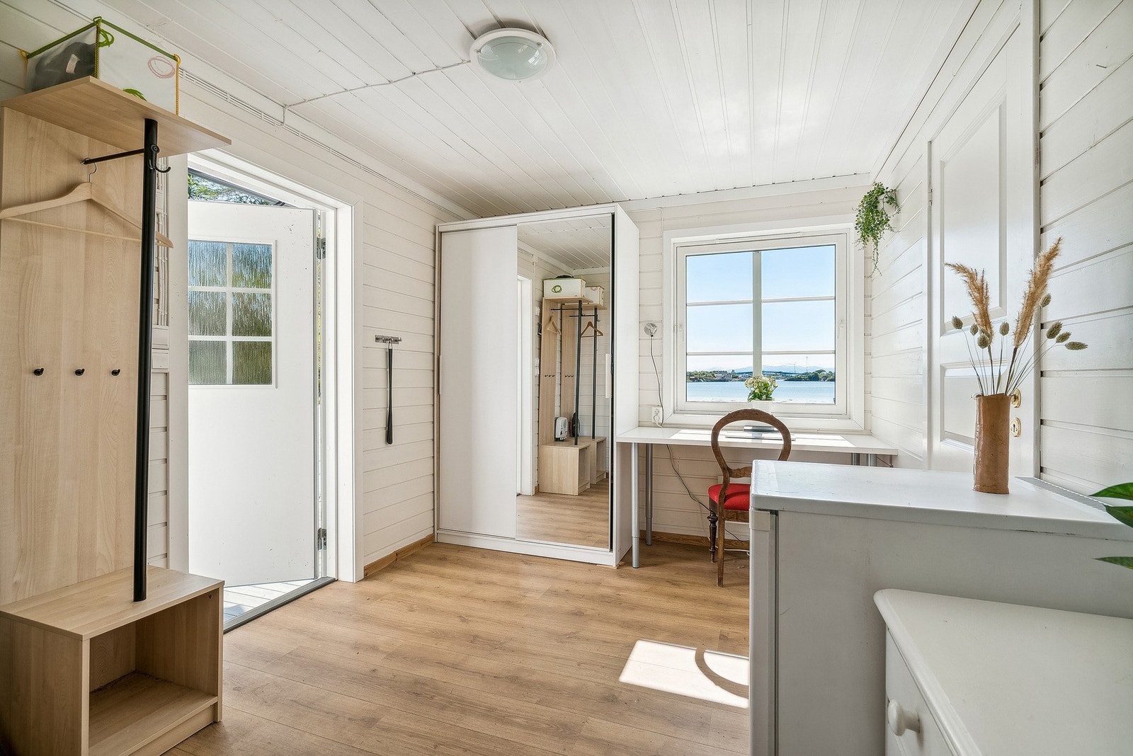 Romslig entré med garderobeløsning og lyse flater. Tilbygd i 2010 Galleribilde