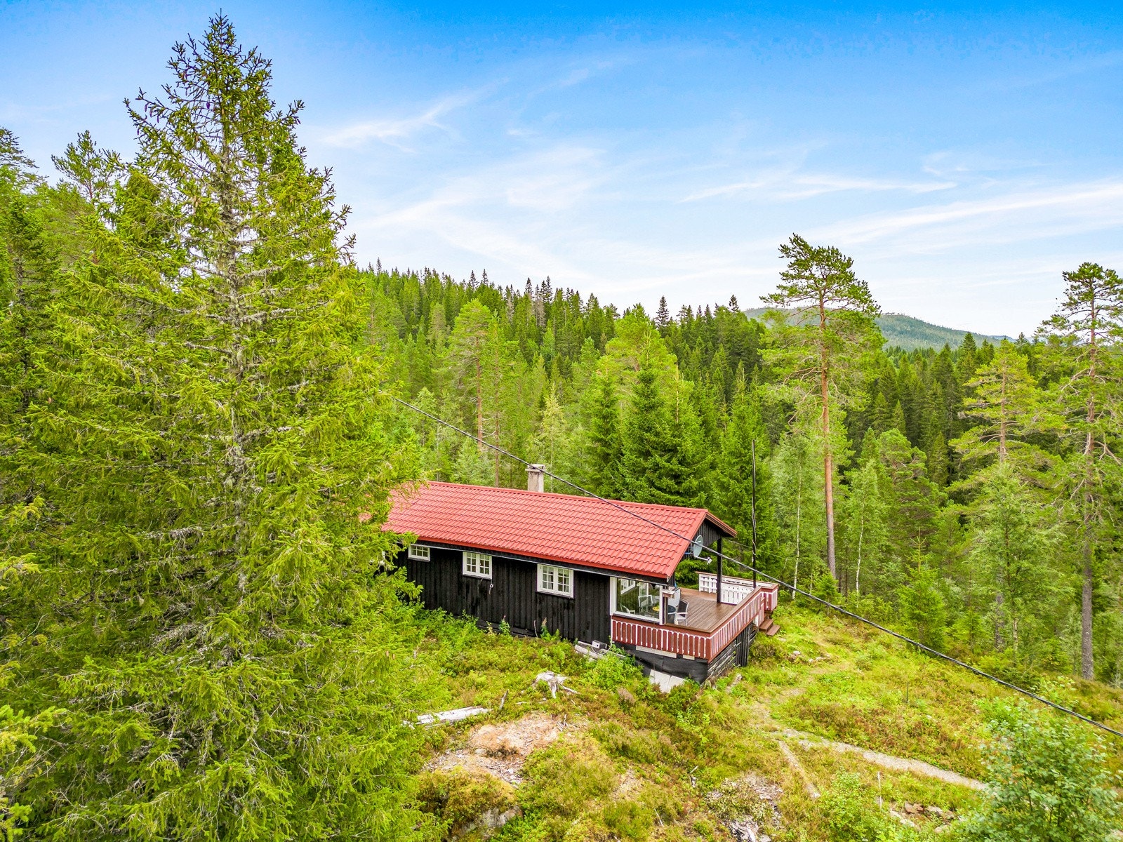 Hytta ligger høyt i terrenget og er sørvendt med fin utsikt Galleribilde