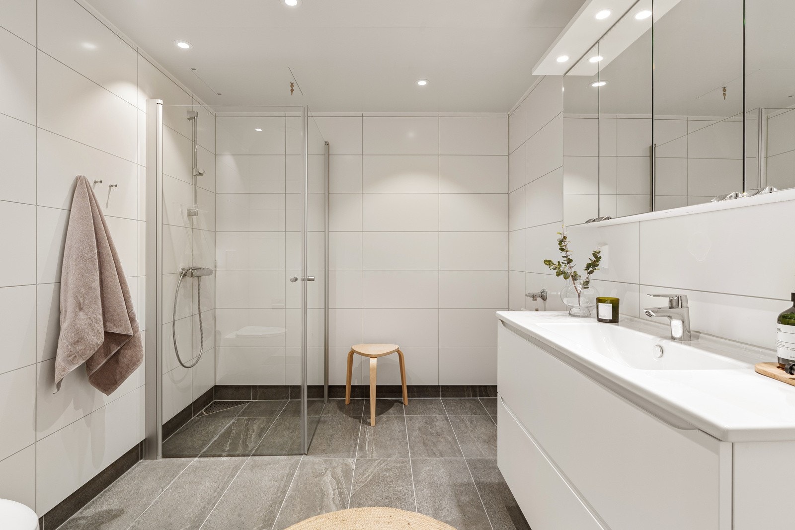 Lekkert, flislagt bad med stort dusjhjørne, vegghengt wc og opplegg for vaskemaskin. Galleribilde