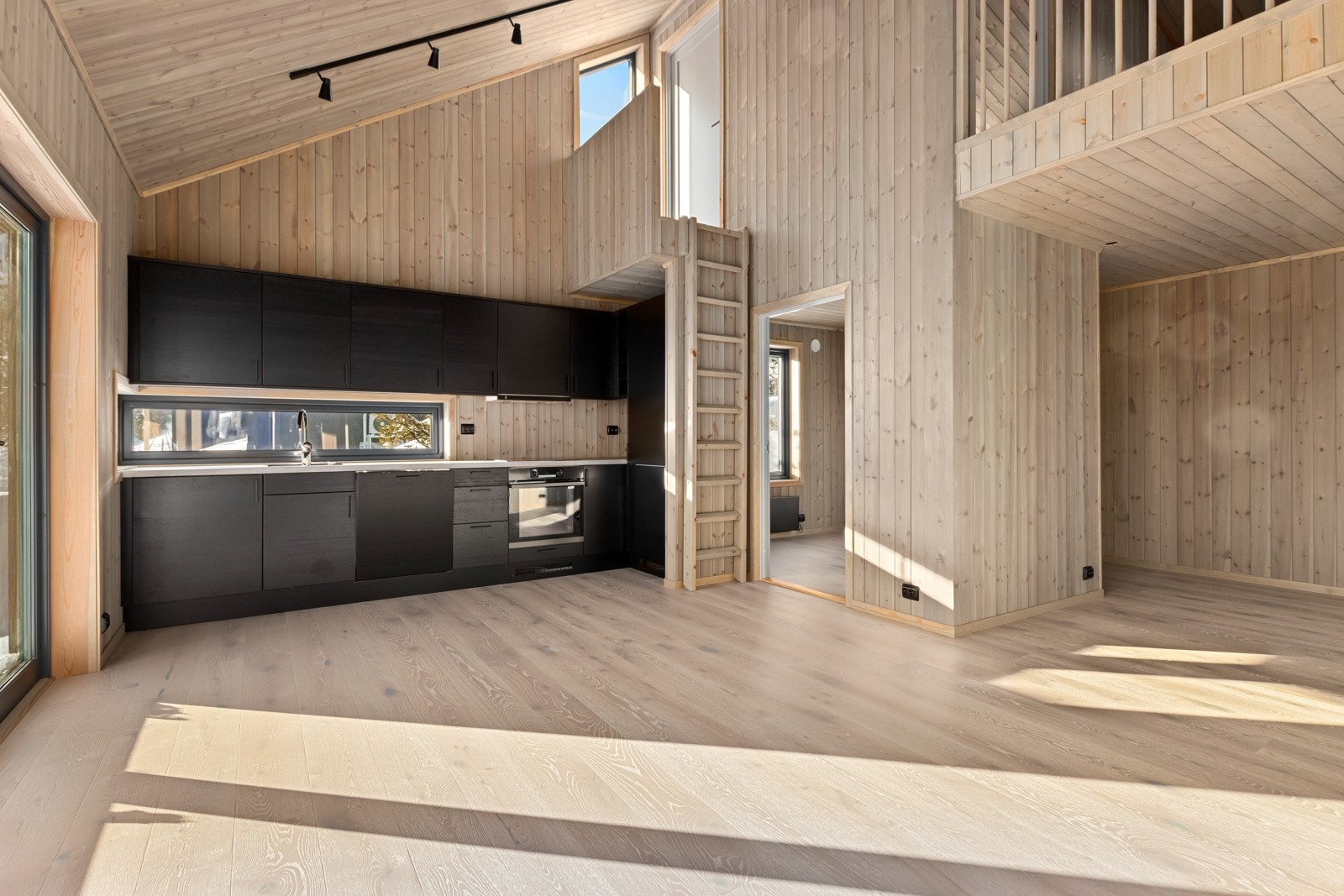 Kjøkken med hvitevarer som kjøl/frys, komfyr med platetopp, oppvaskmaskin og opplegg for vaskemaskin(klesmaskin). Galleribilde