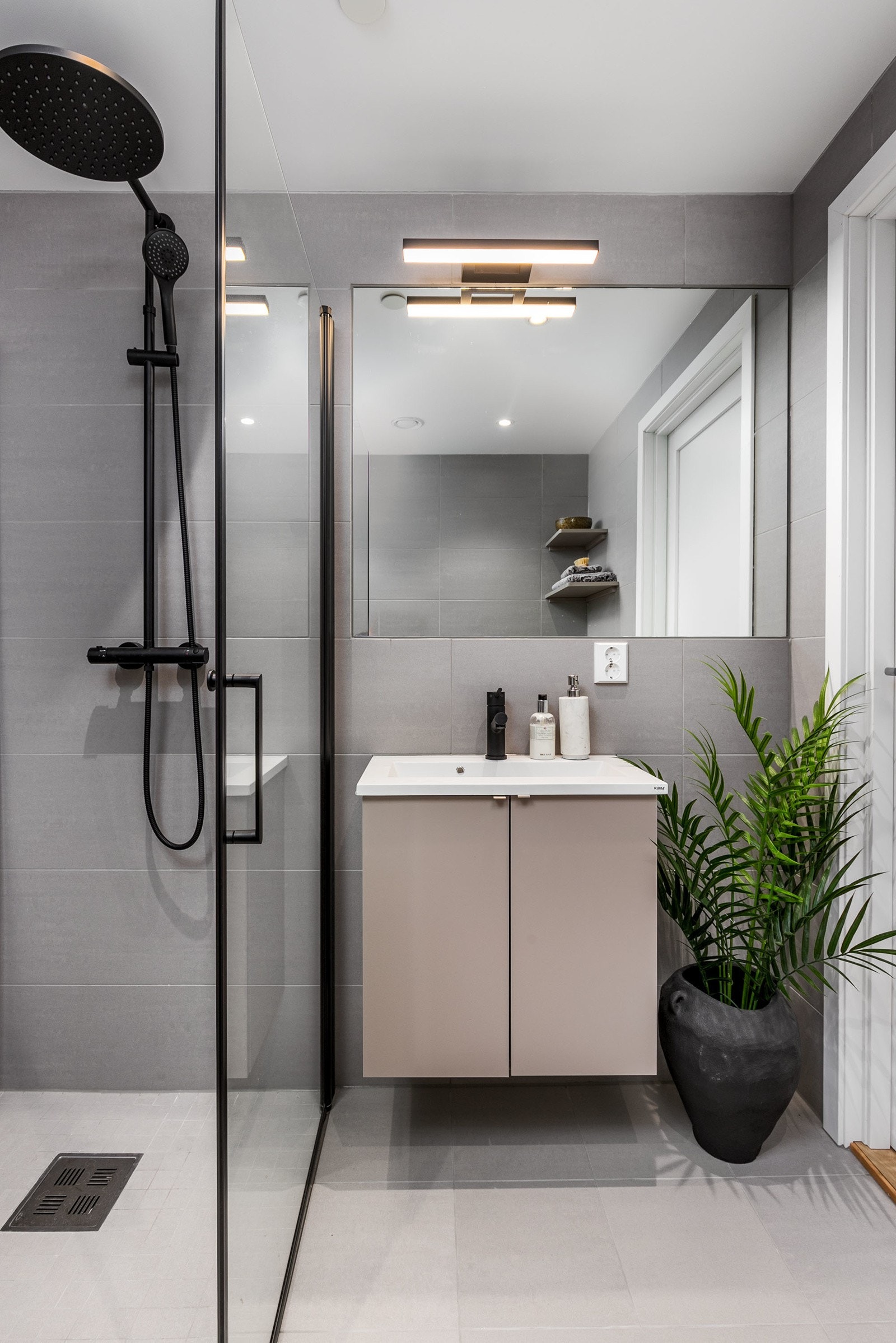 Innbydende og delikat baderom matte grå fliser og sorte detaljer Galleribilde