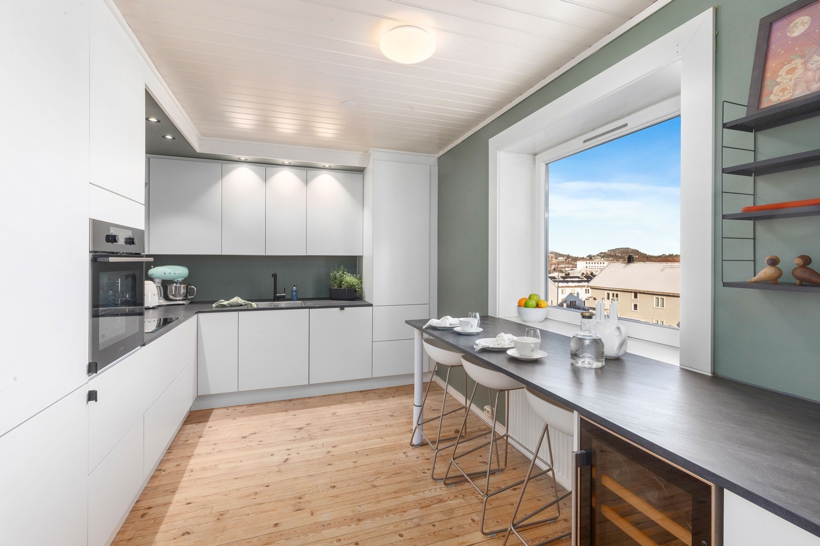 Nyere kjøkken fra Design
a med hvite fronter og laminat benkeplate. Galleribilde