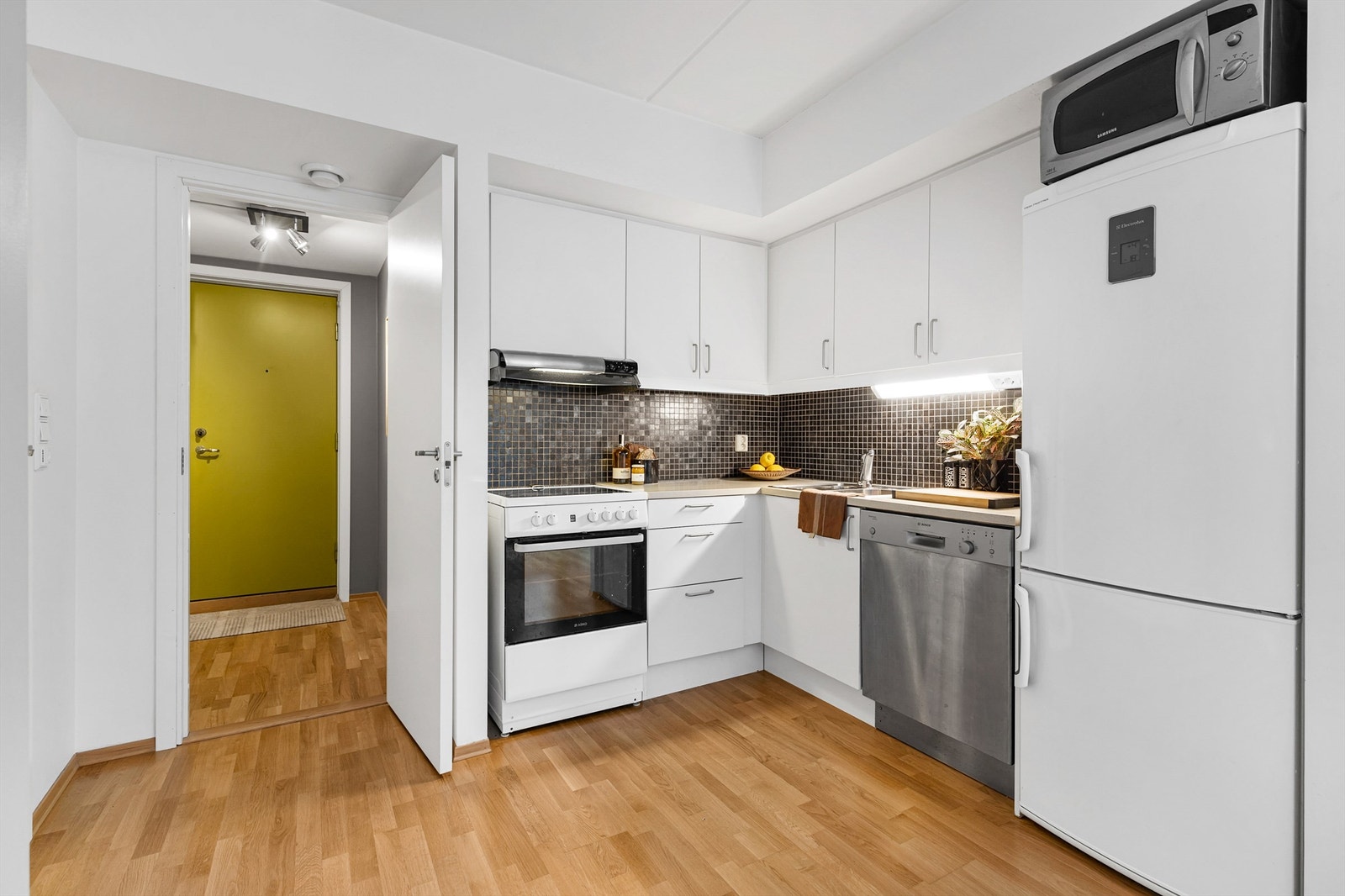 Kjøkkeninnredning fra byggeår i 2010 med glatte hvite fronter. Benkeplater av laminat med nedfelt oppvaskkum med ett-greps armatur. Galleribilde