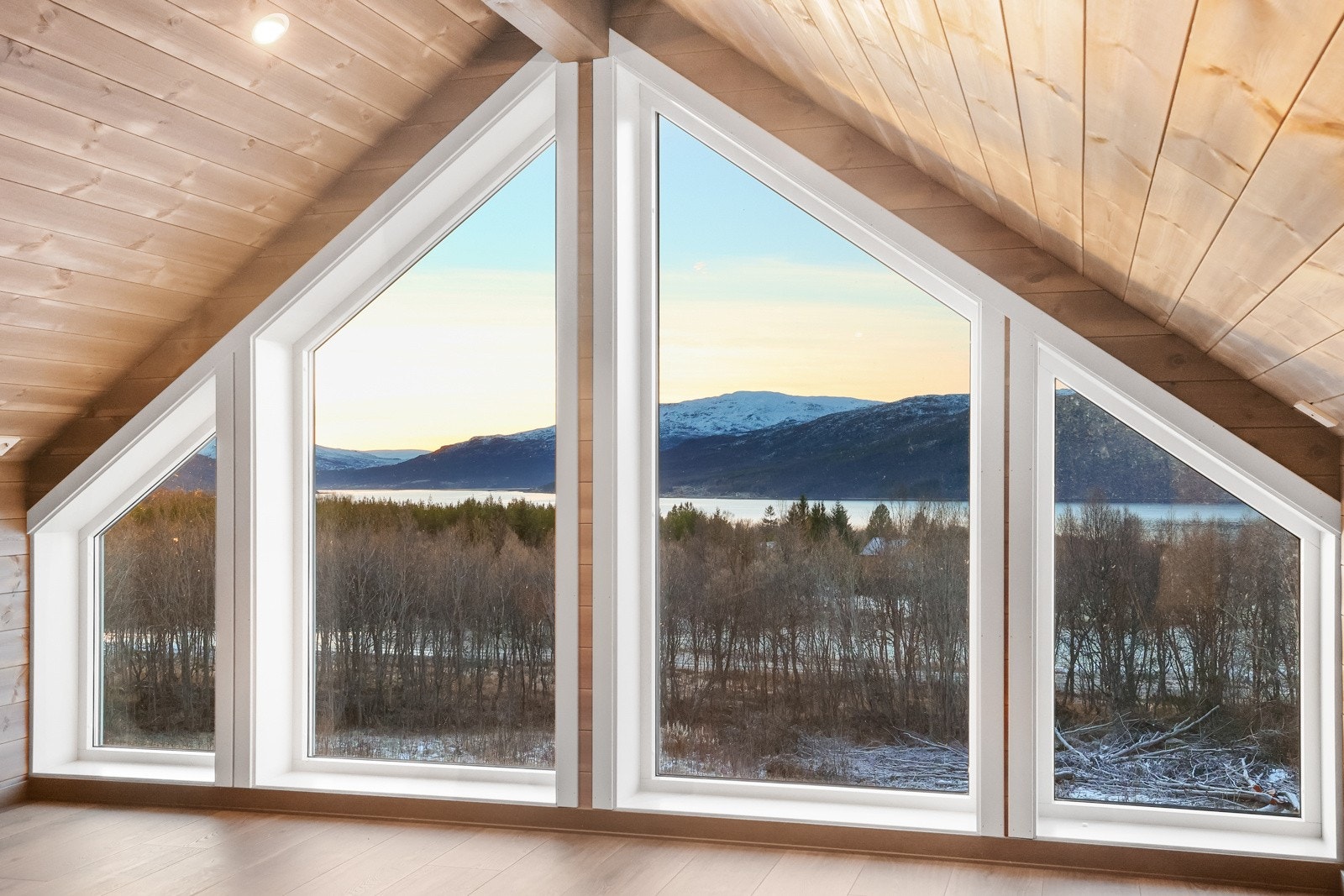Store vinduer med utsikt mot sjø og fjell Galleribilde