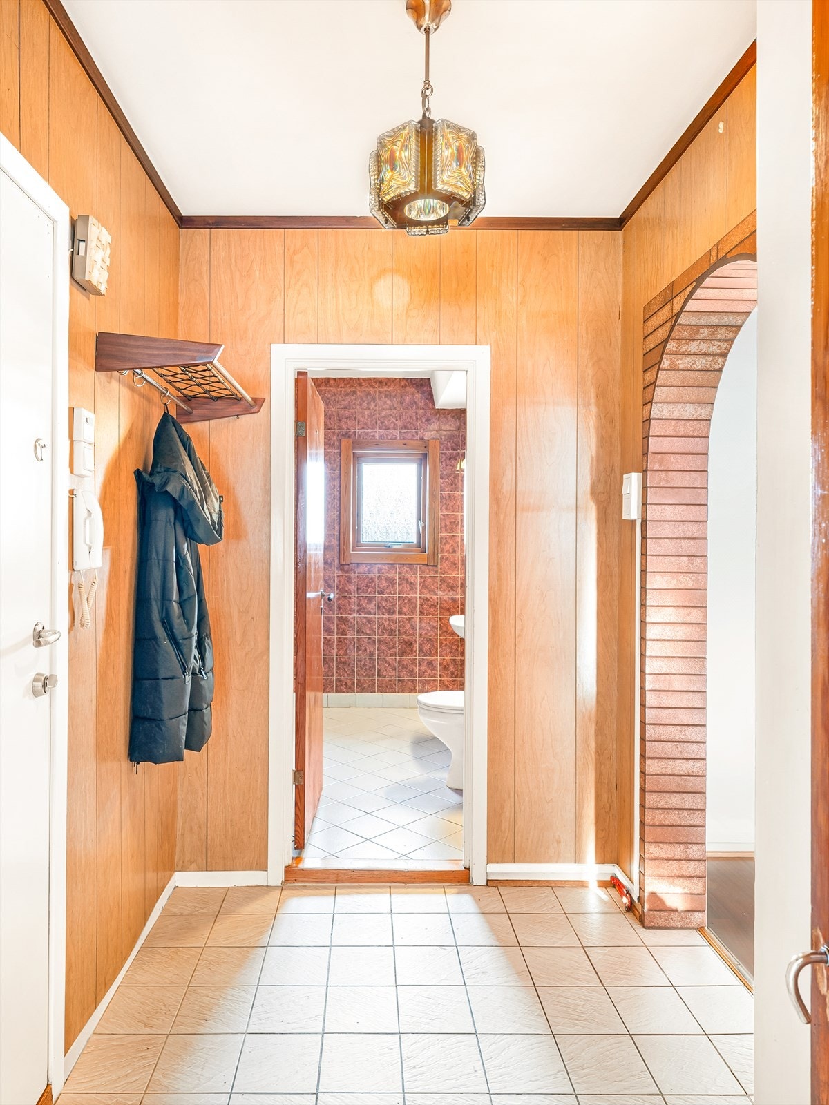 Inngangsparti med flislagt gulv og plass for å henge fra seg yttertøy og sette fra seg sko. Galleribilde