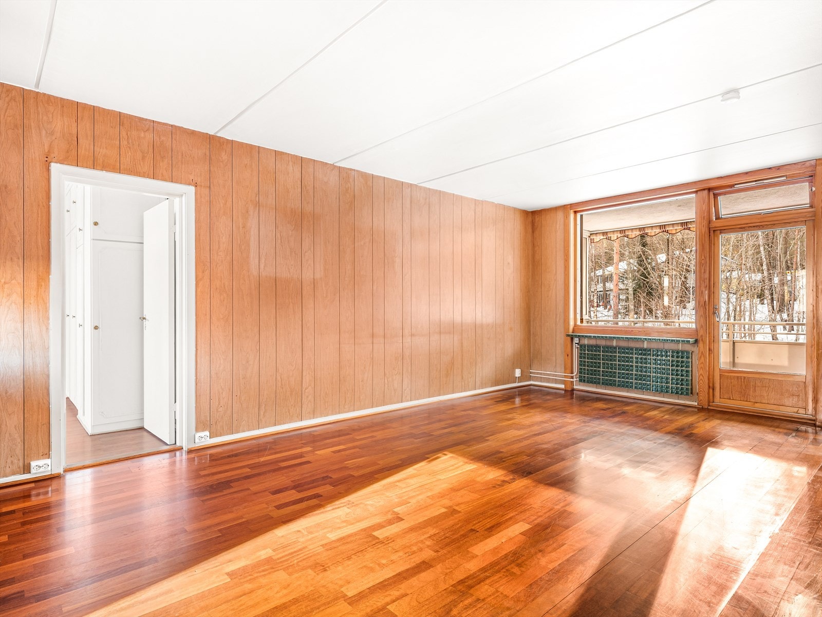 Romslig stue med pen parkett og utsikt til grøntområder. Galleribilde