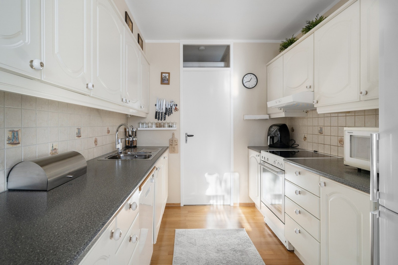 Lyst kjøkken med profilerte fronter og benkeplate av laminat. Galleribilde