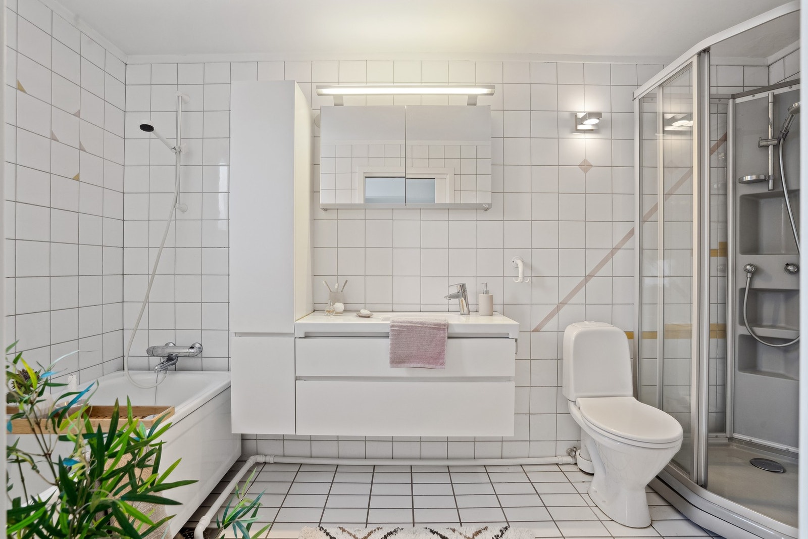 Badet er romslig, komplett flislagt og med både dusj og badekar. Galleribilde