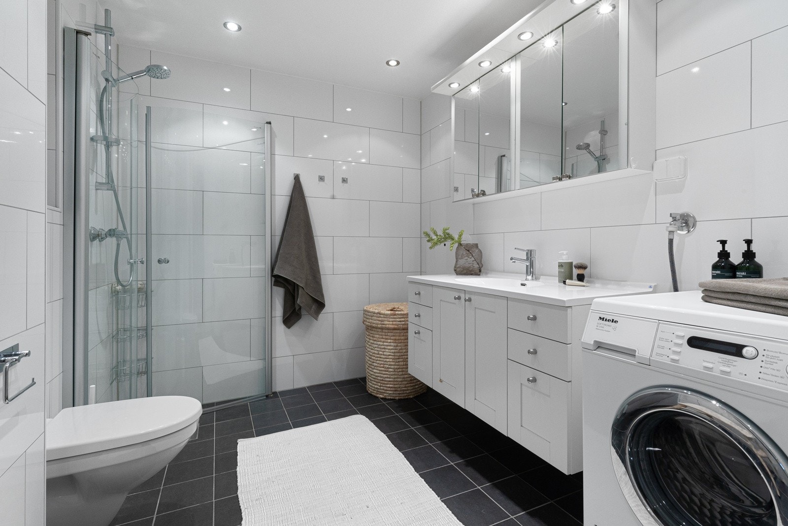 Meget innbydende flislagt baderom av god størrelse med et moderne og tidløst design. Galleribilde