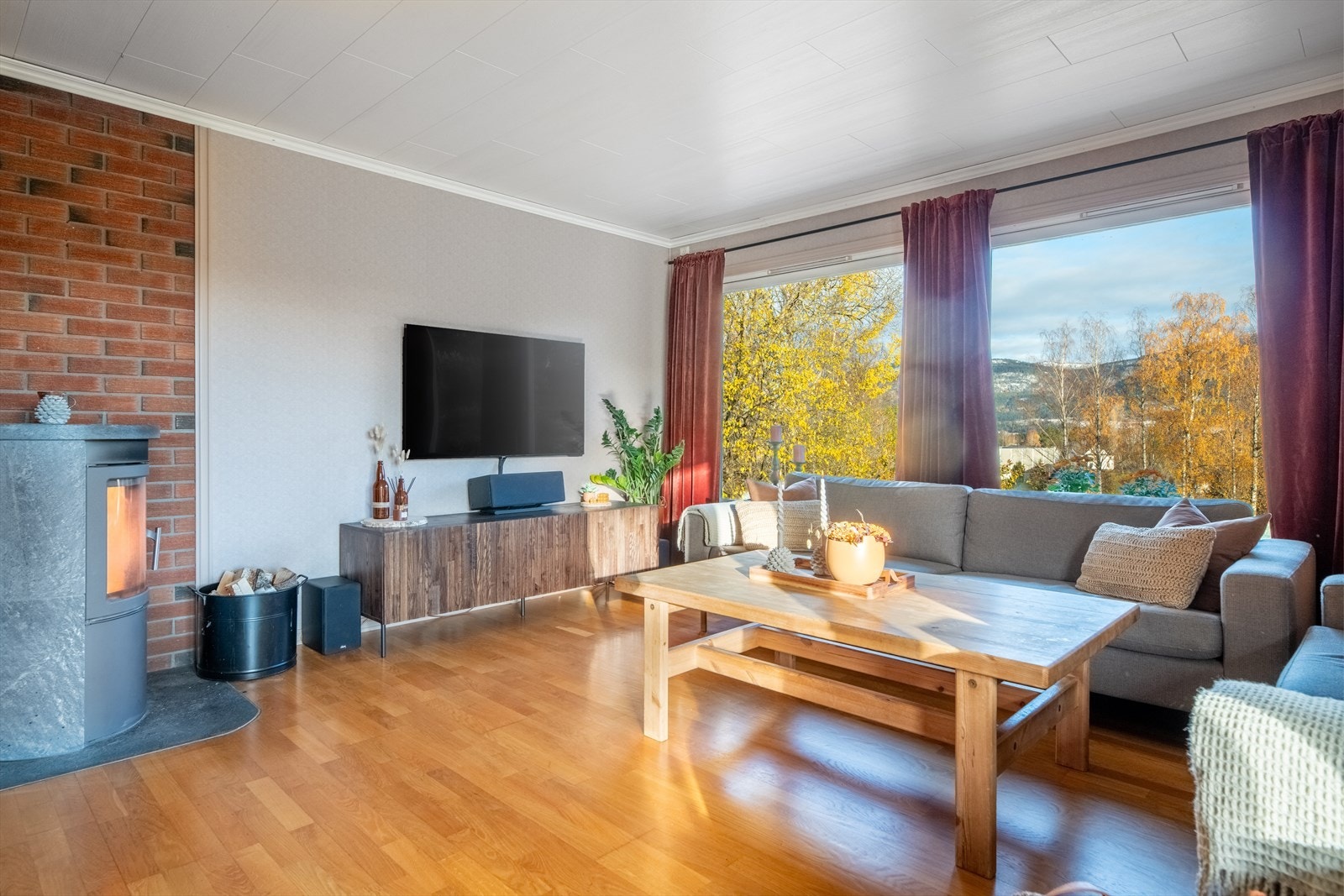 Sentralt i rommet er det etablert ildsted, med nyere og moderne vedovn som sørger for lun og god varme vinterstid. Galleribilde