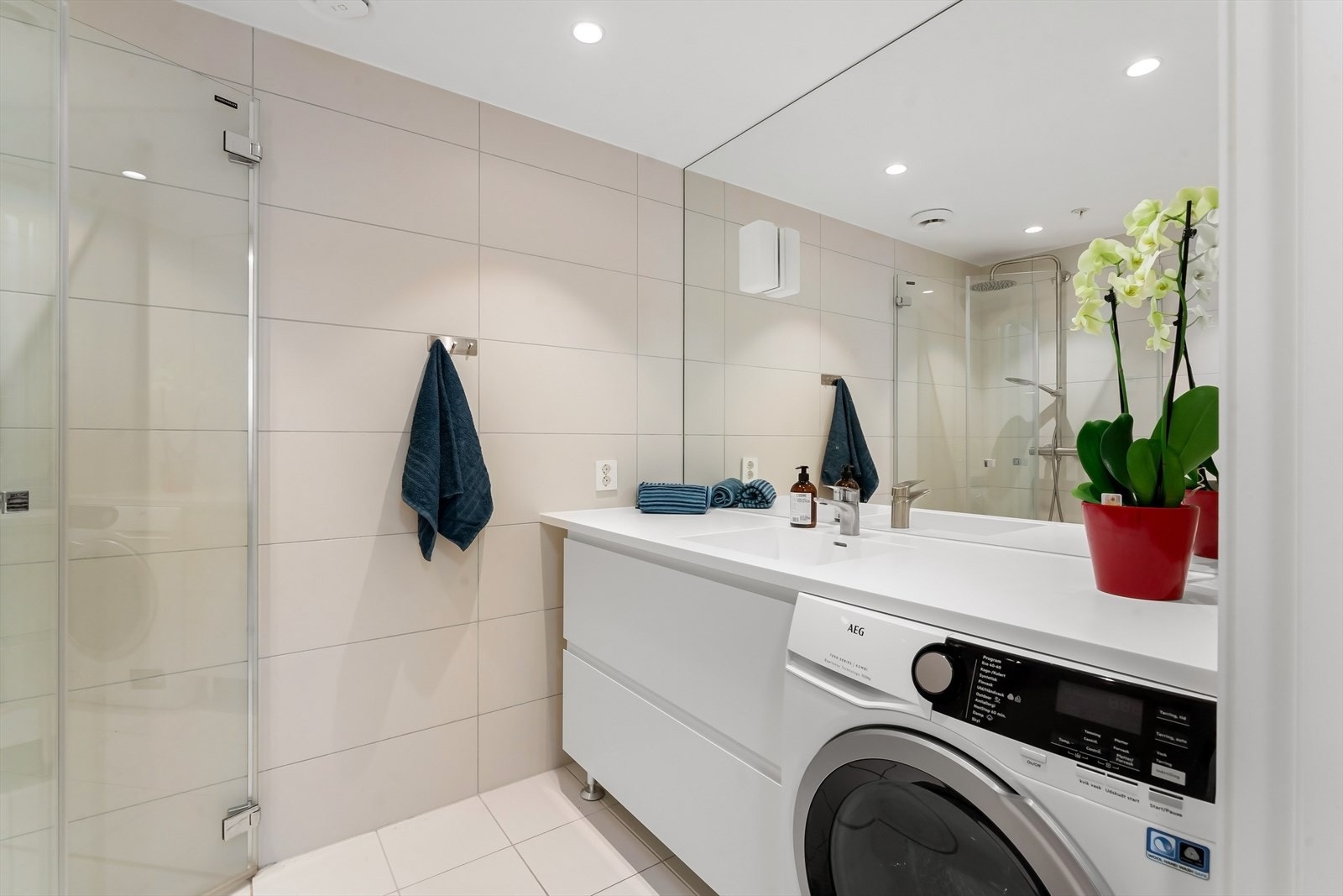 Badet er innredet med vegghengt toalett og dusjhjørne med innfellbare glassdører og regnfallsdusj. Galleribilde