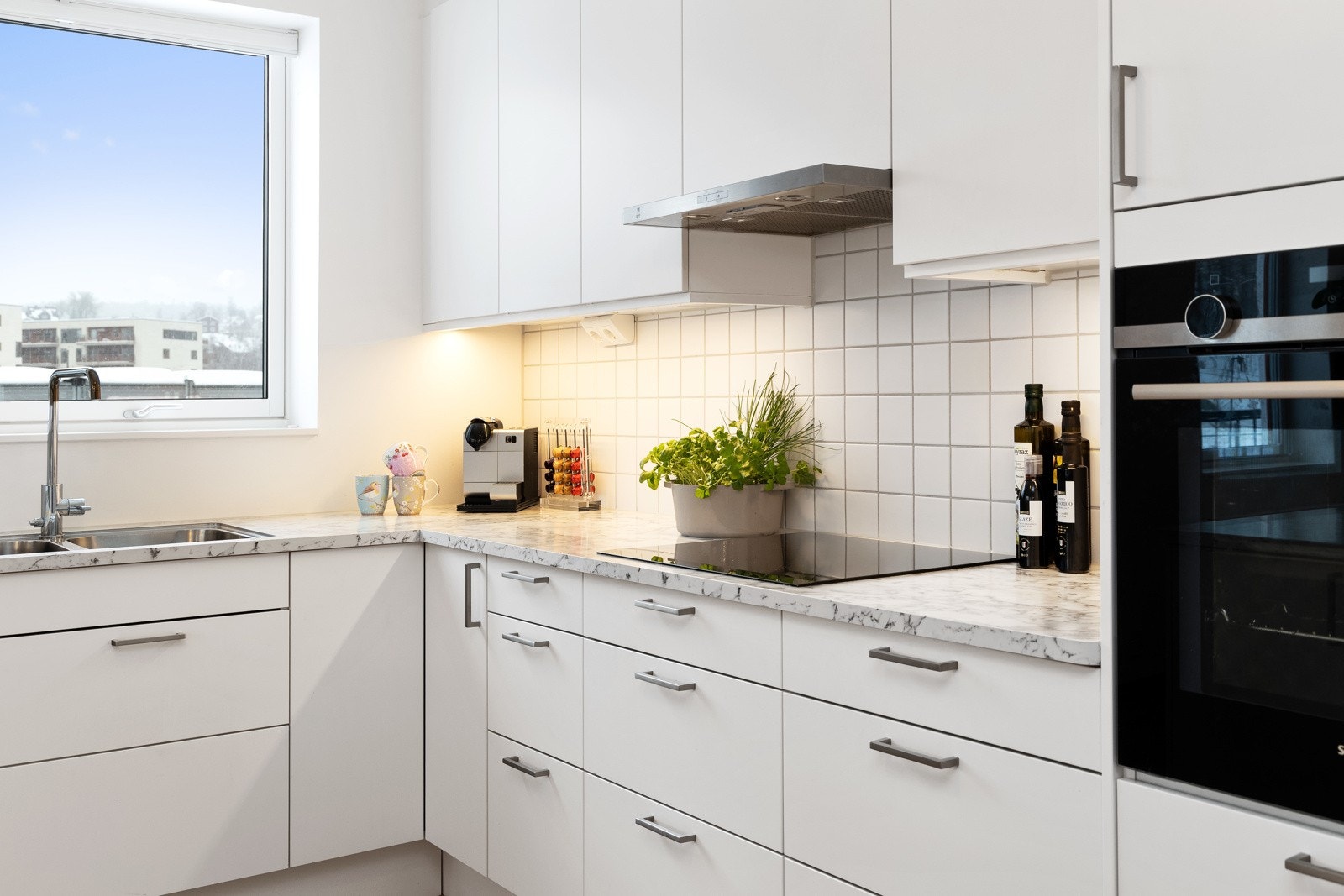 Integrerte hvitevarer som stekeovn, kjøleskap, platetopp og oppvaskmaskin. Galleribilde