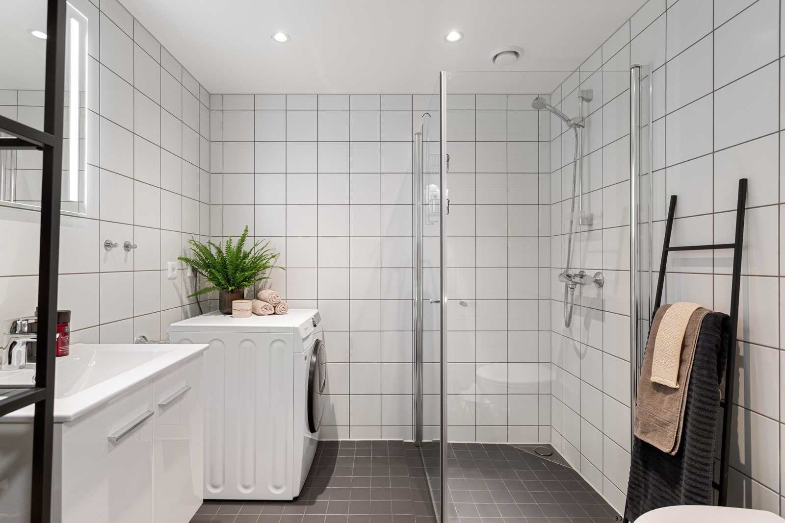 Lyst og tidløst baderom med flislagte gulv og vegger, samt gulvvarme. Galleribilde