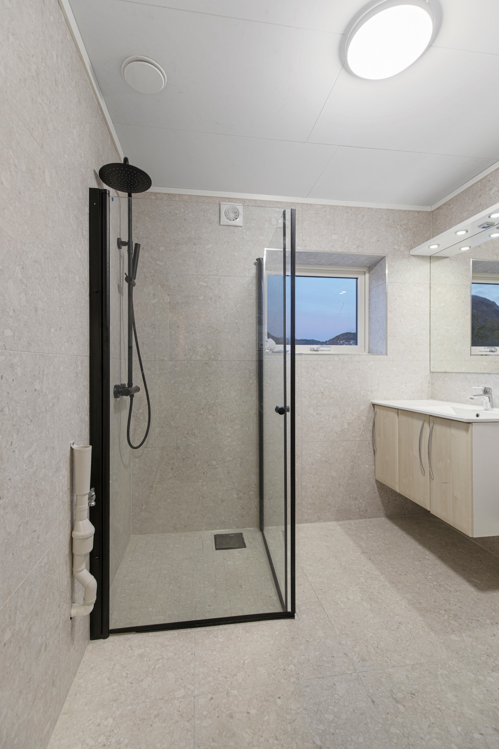 Nyrenovert og helfliset bad. Rommet har varmekabler i gulv, dusj med dusjvegger og vegghengt toalett. Galleribilde