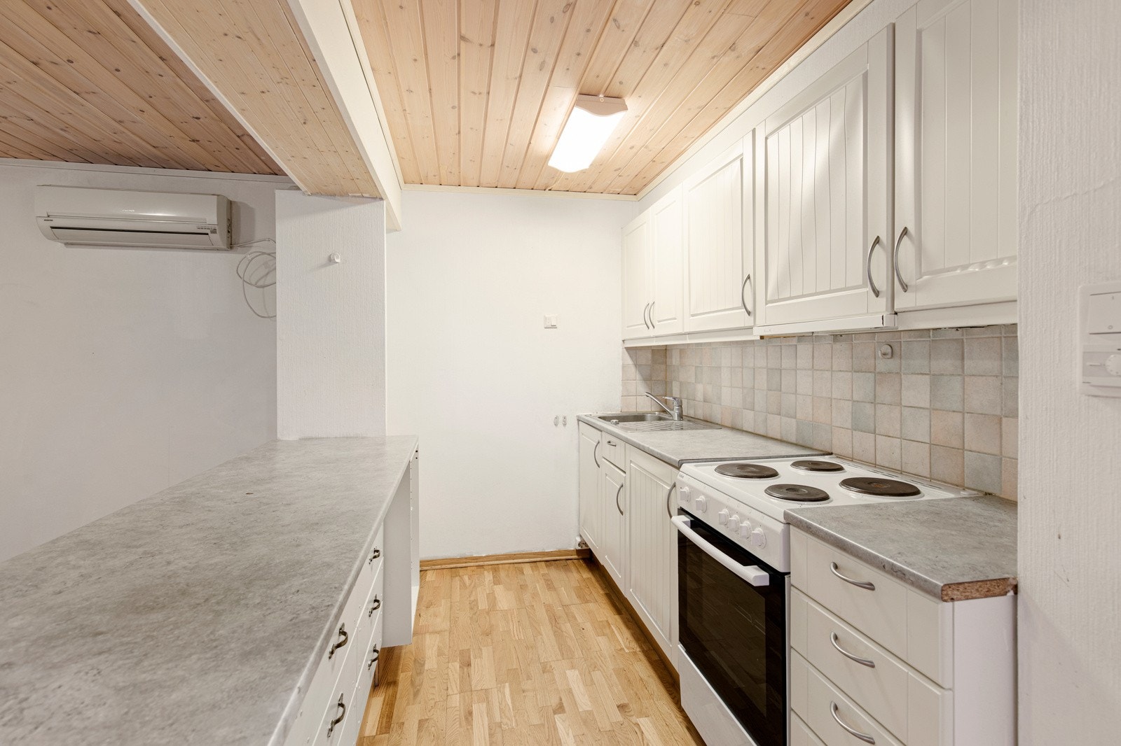 Åpen kjøkkenløsning med innredning i hvite, profilerte fronter. Galleribilde