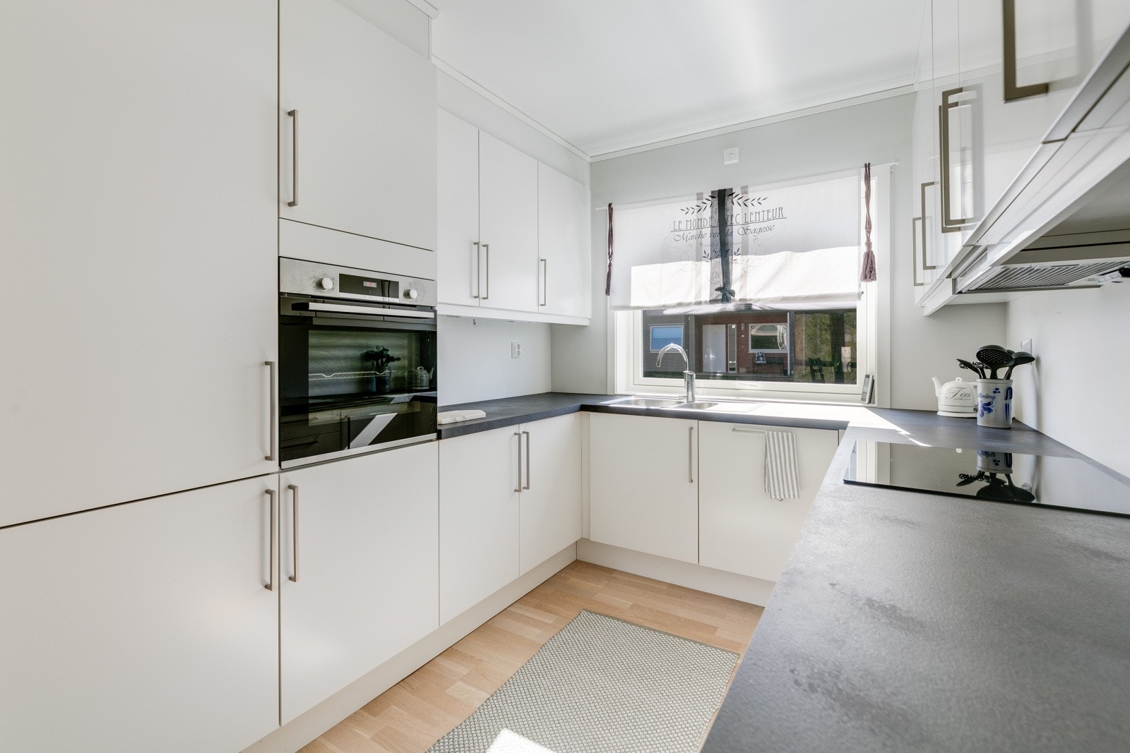 Kjøkkeninnredning med glatte fronter og integrerte hvitevarer. Galleribilde