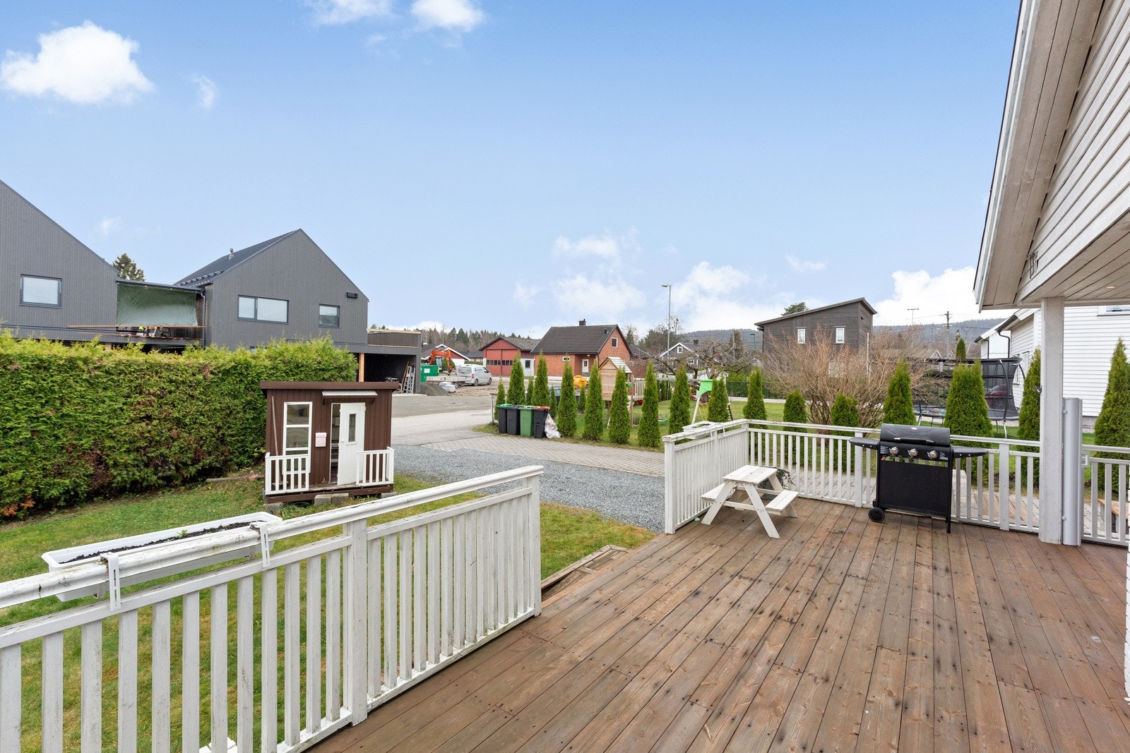 Romslig terrasse delvis overbygget og inngjerdet og med trapper ut til hagedel Galleribilde