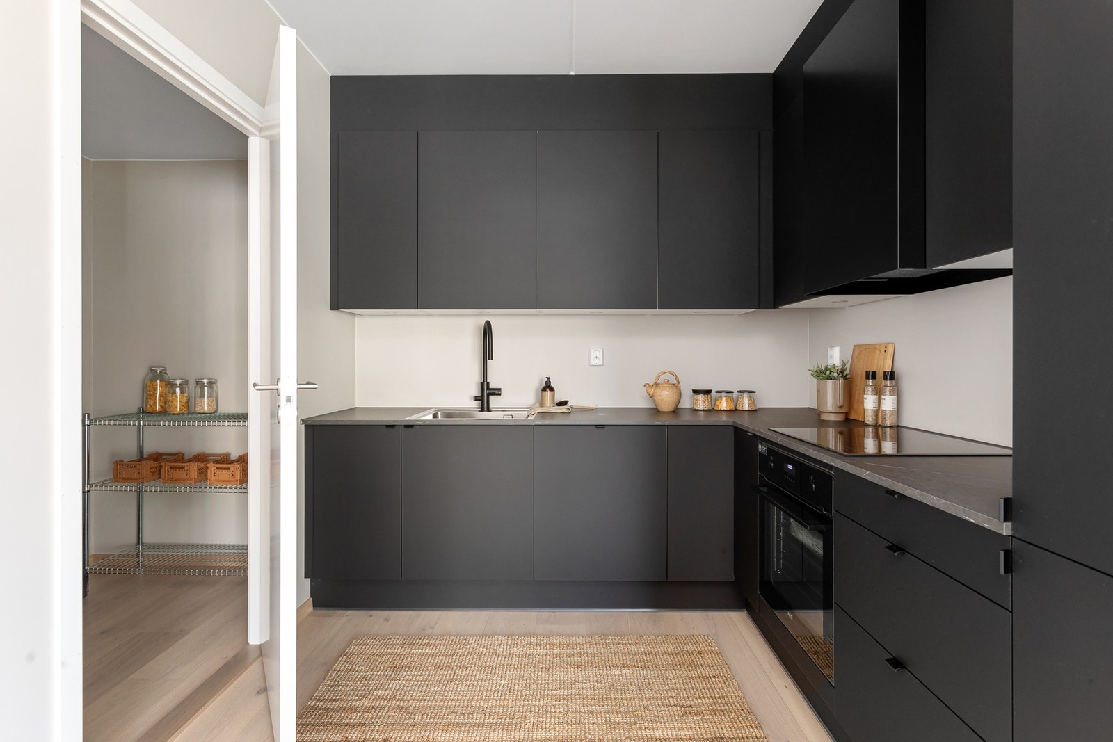 Påkostet med sort armatur fra Tapwell med uttrekkbar hånddusj. Praktisk med innfelte downlights under de takhøye overskapene. Galleribilde