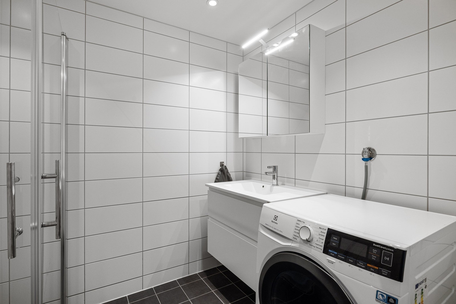 Leilighetens største baderom. Speil med overlys og stikkontakt over servant. Galleribilde