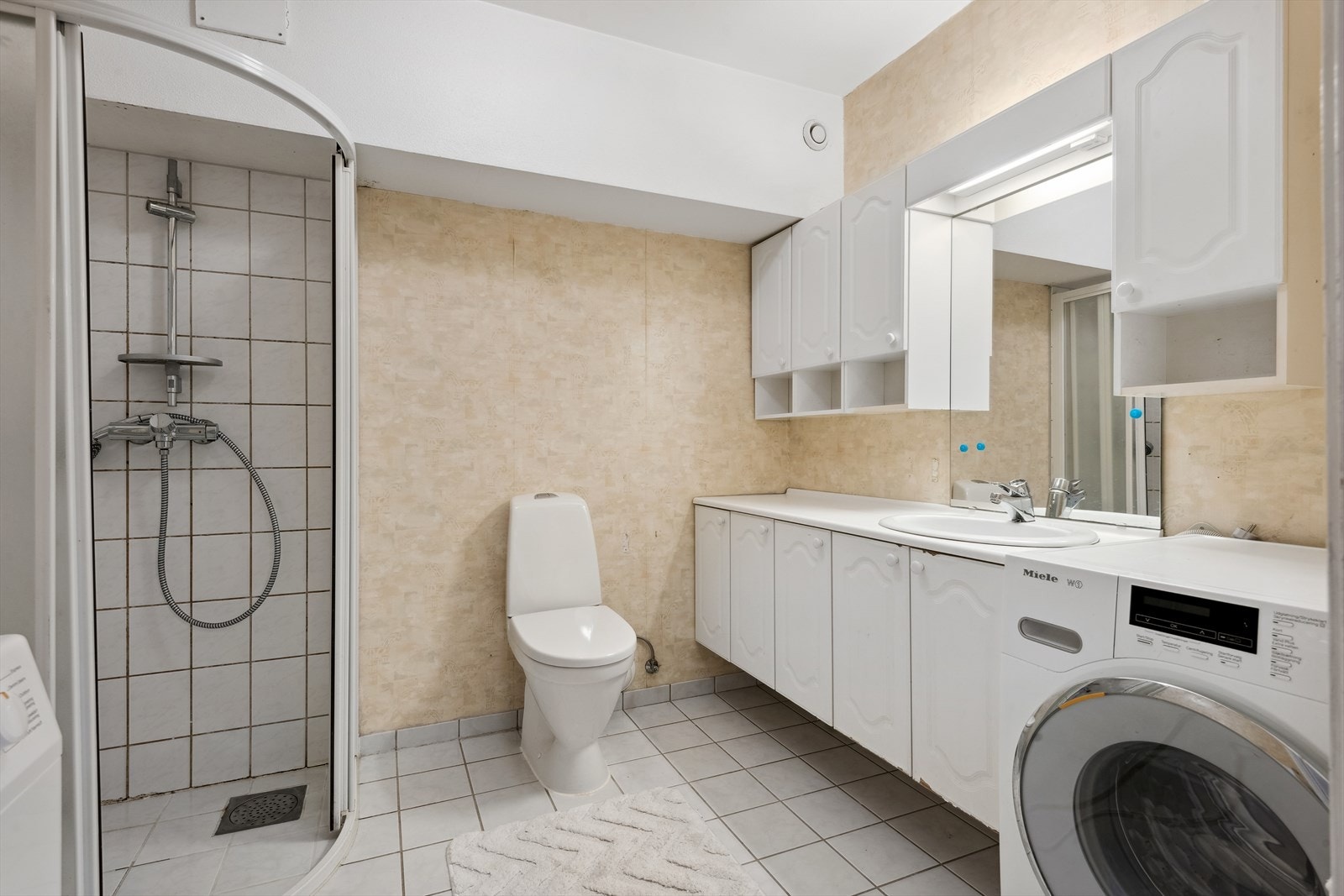 Badet inneholder innredning med nedfelt servant, gulvfestet toalett,
dusjhjørne og opplegg for vaskemaskin. Stråleovn på vegg. Galleribilde