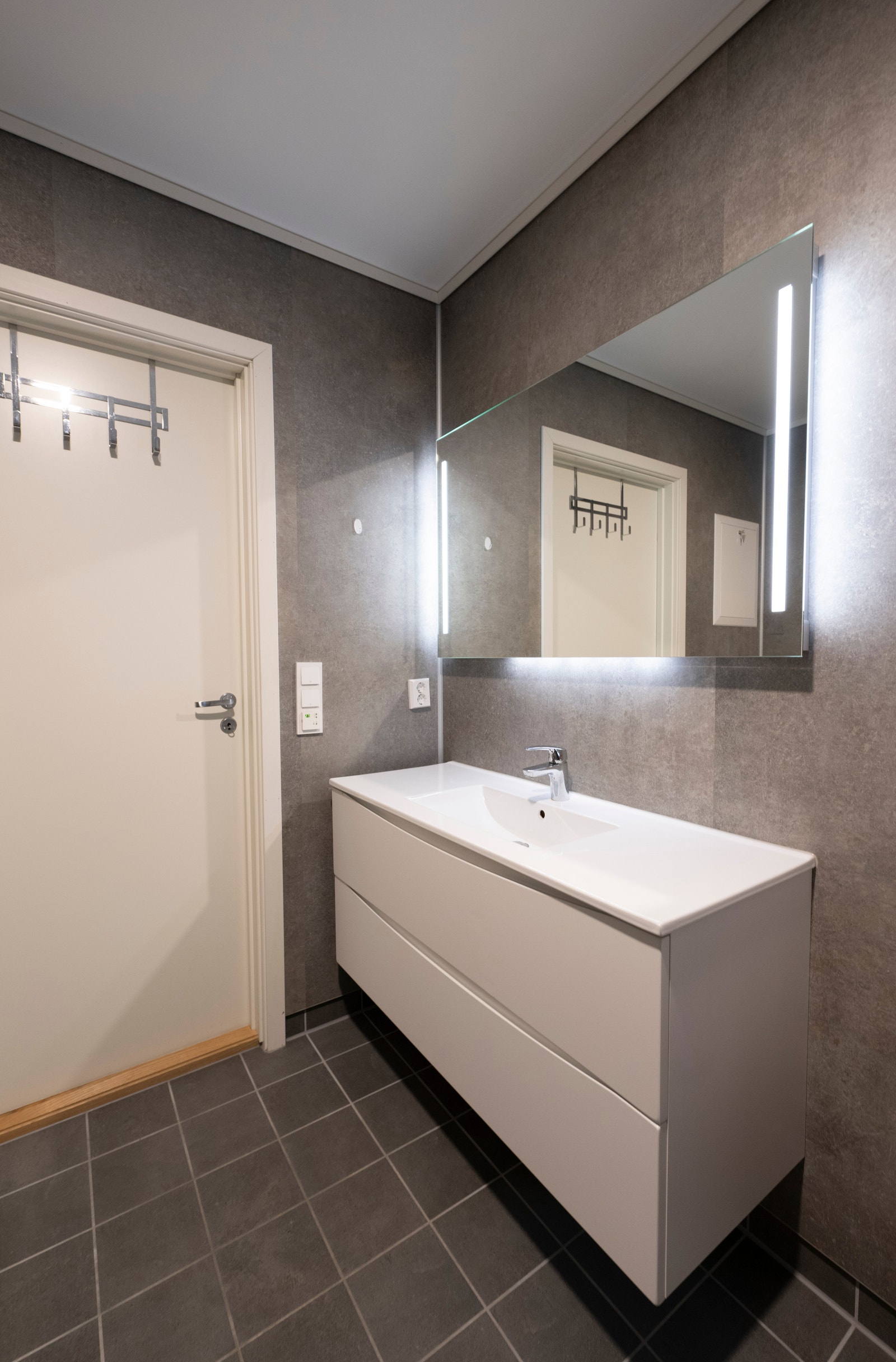 Lekkert bad med baderomsplater, flislaggt gulv og varmekabler Galleribilde