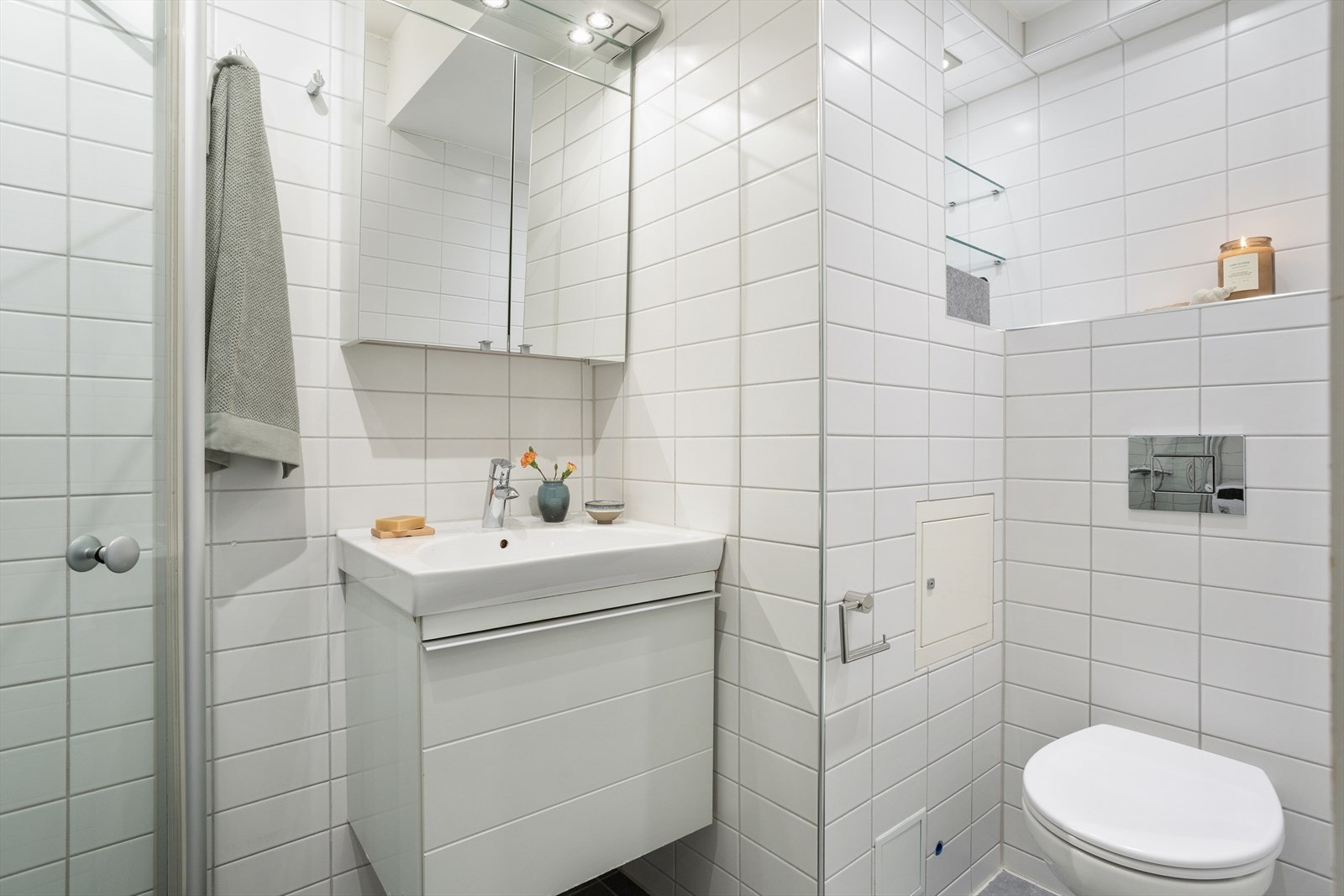 Badet er utstyrt med heldekkende servant og overskap med speilfronter Galleribilde