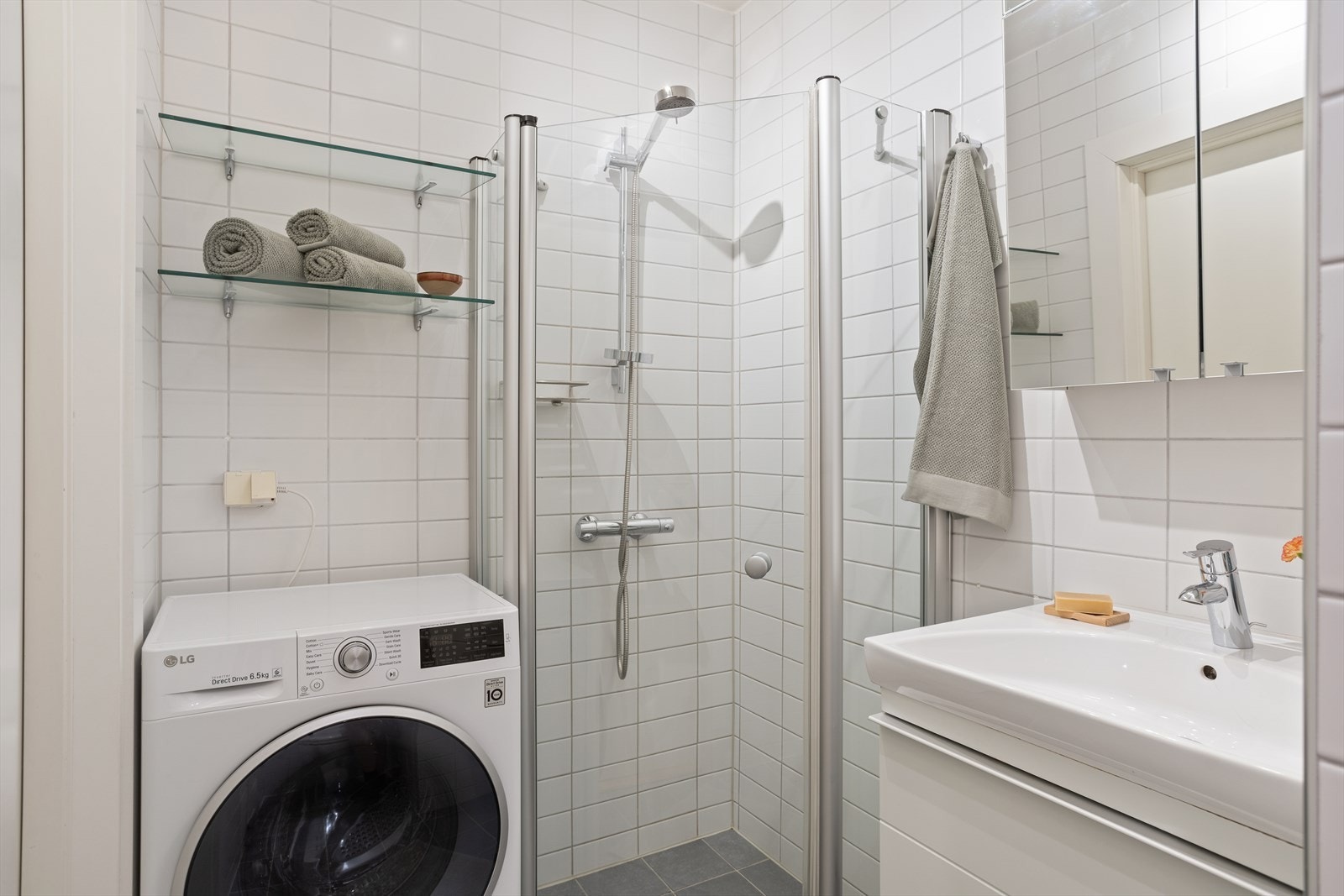 Flislagt bad med opplegg for vaskemaskin og dusjhjørne med glassvegger Galleribilde