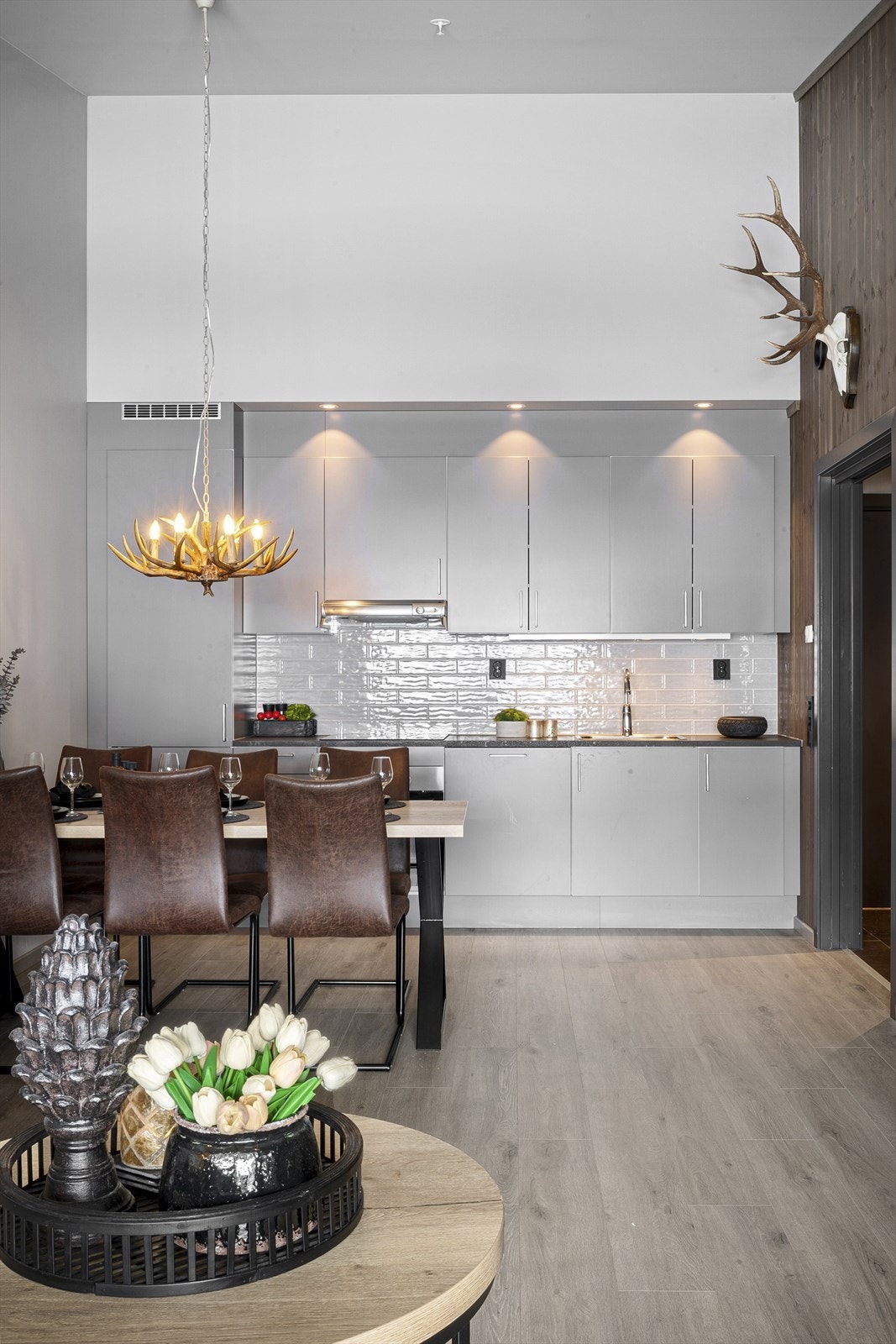 Kjøkkeninnredning med laminert benkeplate med over- og underskap. Det er glatte fronter og fliser i benkerygg. Galleribilde