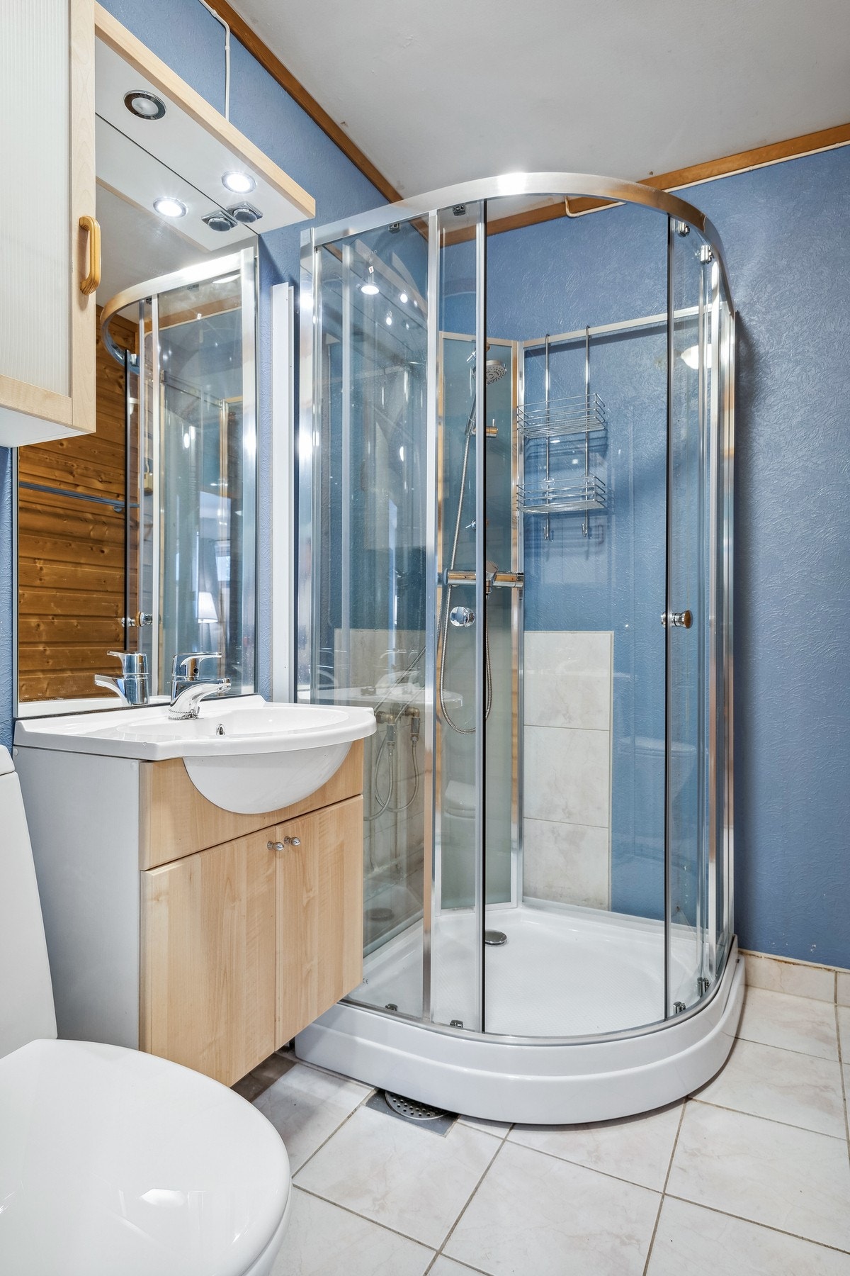 Badet er innredet med bl.a. dusjkabinett, gulvmontert WC, Kran og avløp for vaskemaskin Galleribilde