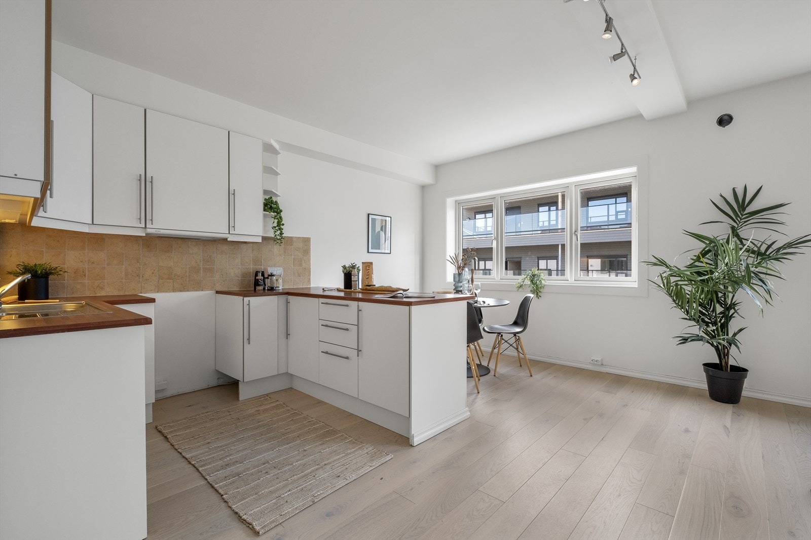 Pen og lys kjøkkeninnredning med godt med skap og benkeplass. Galleribilde