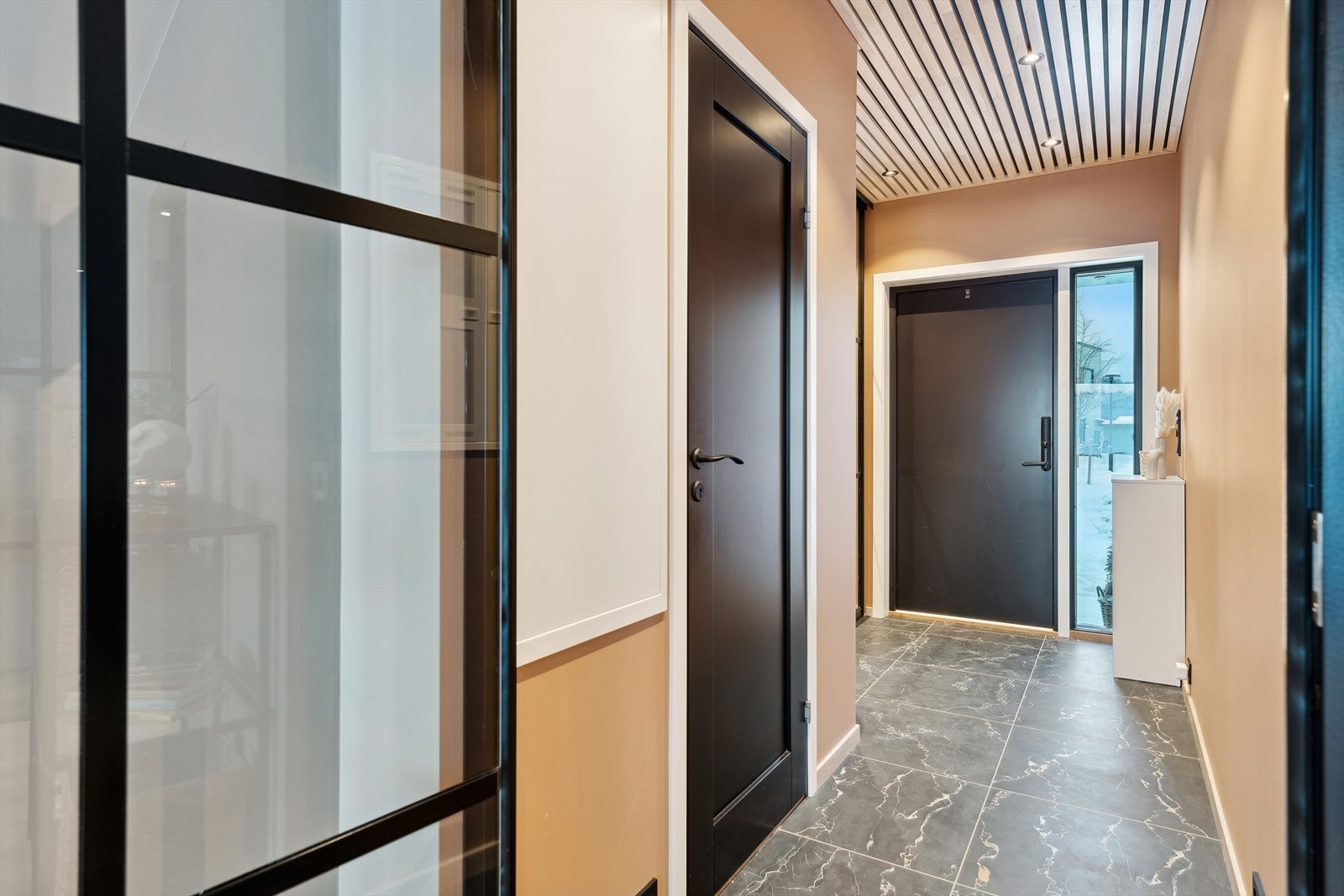 Man ønskes velkommen av en innbydende gang, med store, oppgraderte fliser og skyvedørsgarderobe fra OPAS Garderober. Galleribilde