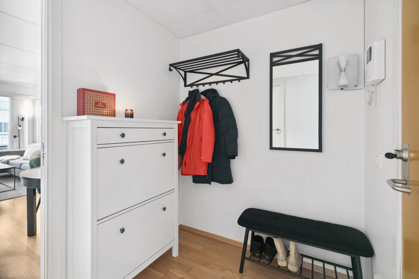 Lys entrè med plass til sko og tøy. Dørcalling med kamera. Galleribilde