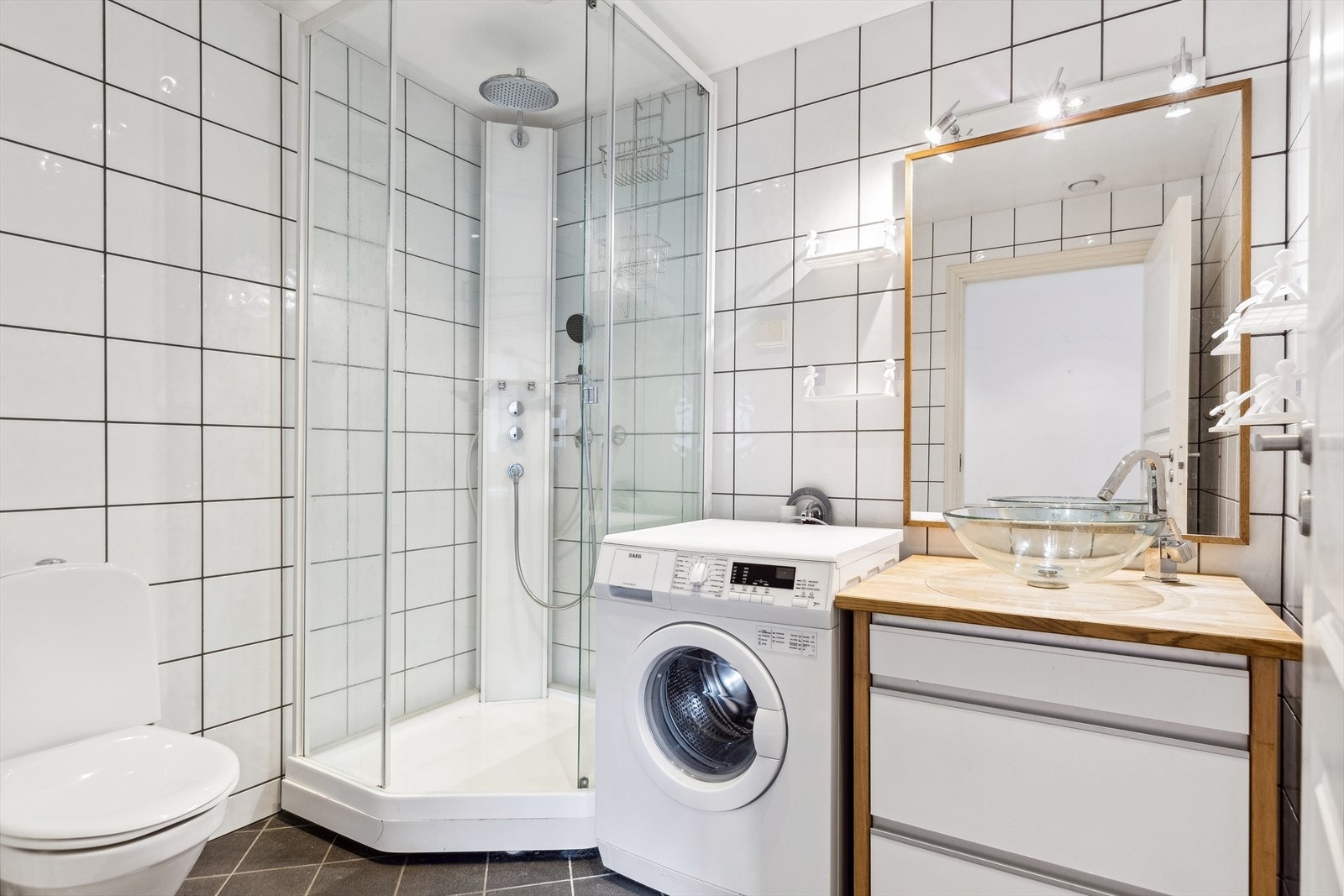 Flott flislagt bad på 4,5m² som er innredet med downlights i himling, behagelig gulvvarme, servantskap, mekanisk avtrekk, opplegg for vaskemaskin, wc og dusjkabinett. Galleribilde