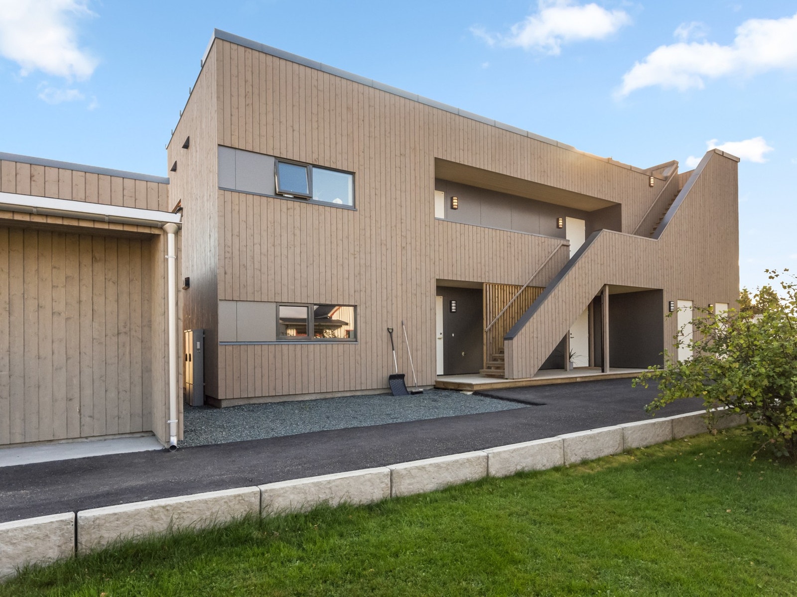 Pent opparbeidet fellesareal med delvis asfaltert gårdsplass. Galleribilde