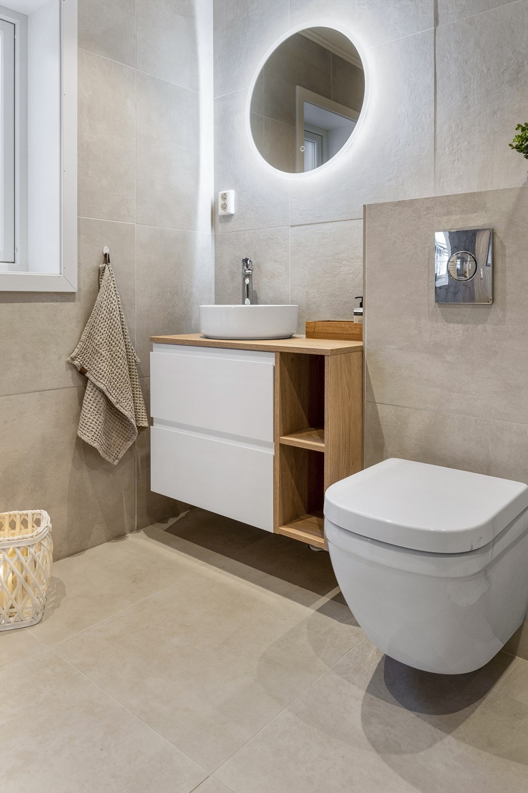 Benkeskap med bolleservant og vegghengt toalett. Det er også vindu på badet som slipper inn godt dagslys. Galleribilde