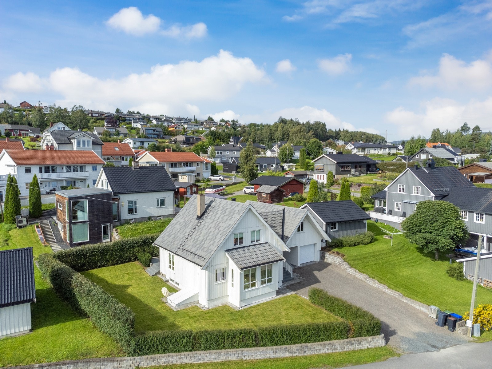 Tomten er pent opparbeidet med plan, støttemurer og hekk. Galleribilde