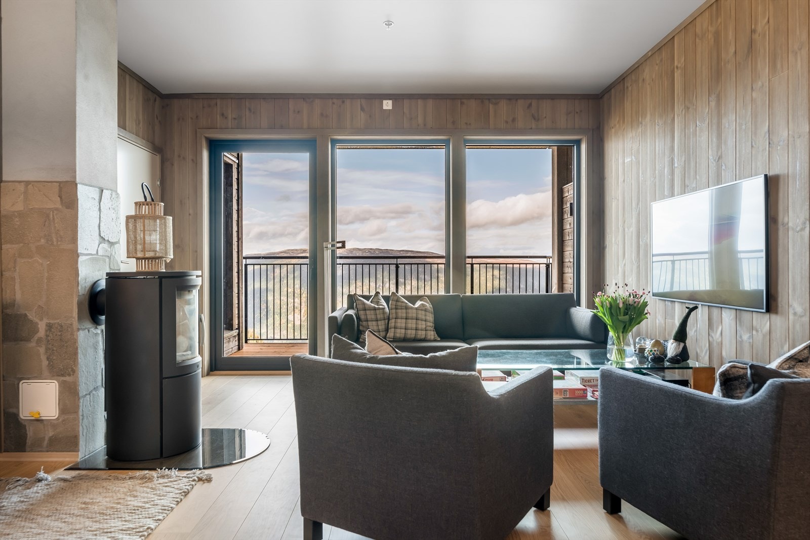Her er det en flott stue med plass til sofagruppe og spisestuebord.
Det er store vindusflater som slipper godt med lys inn og gjør at den fantastiske utsikten også kan nytes inne fra boligen. Galleribilde
