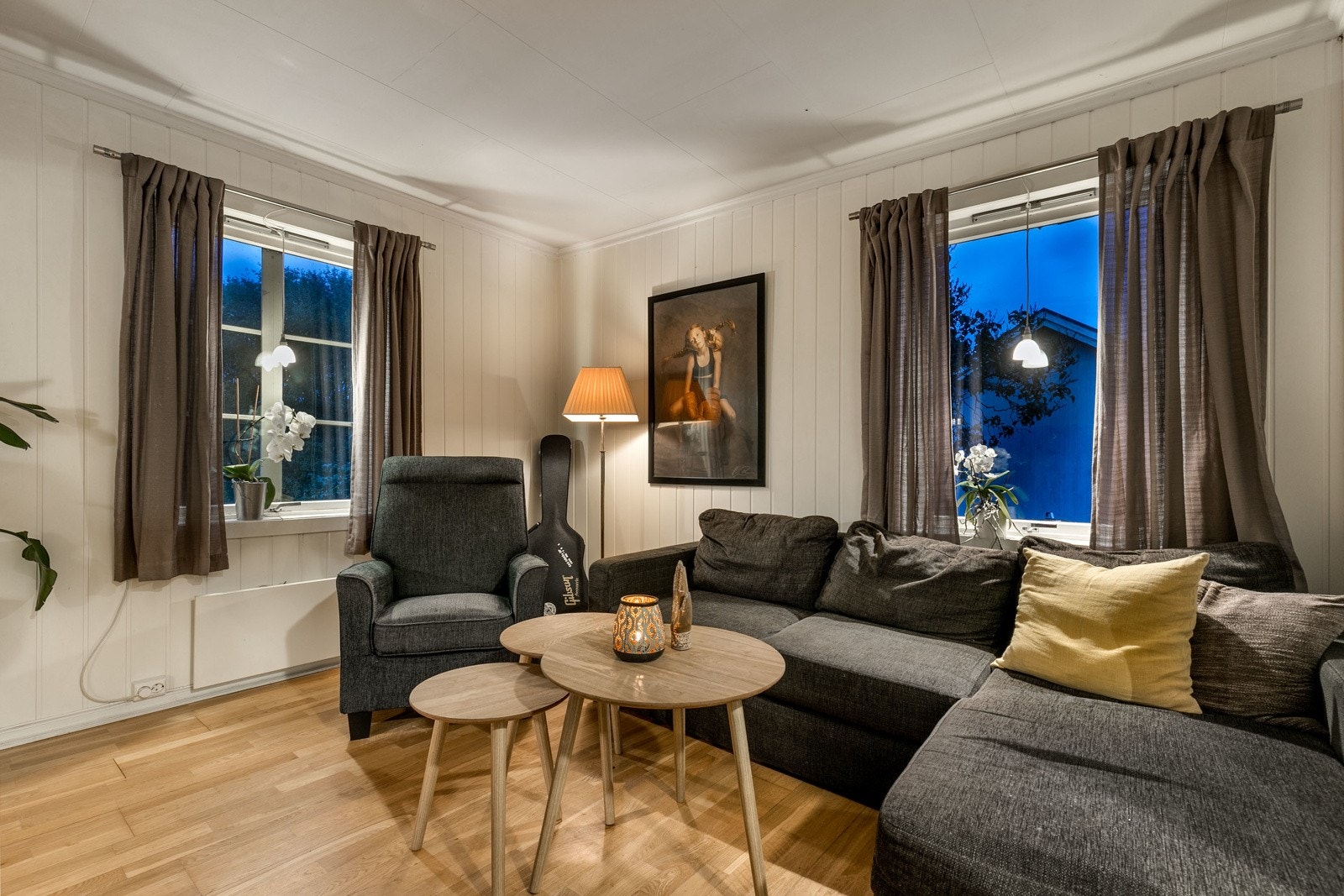 Åpen og trivelig stue og spisestue med trestavs parkett på gulv og lysmalte vegger. Galleribilde