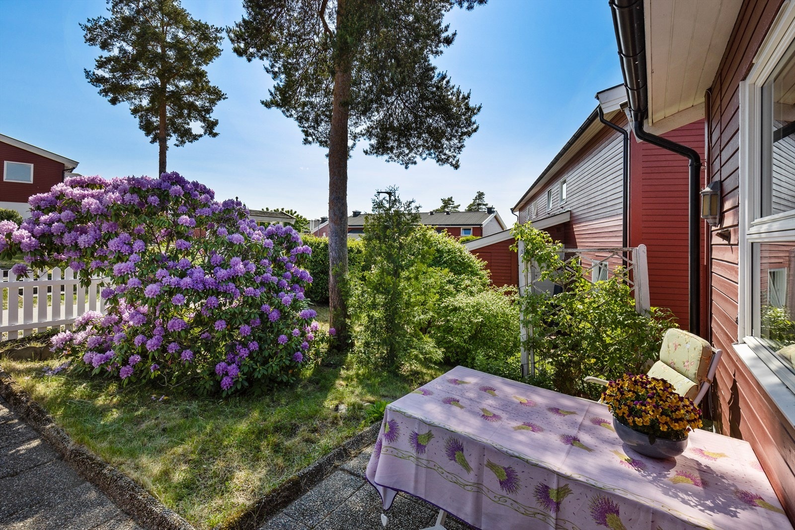 I hagen er det frodig beplantning, og det hvite gjerdet setter et idyllisk preg på boligen. Galleribilde