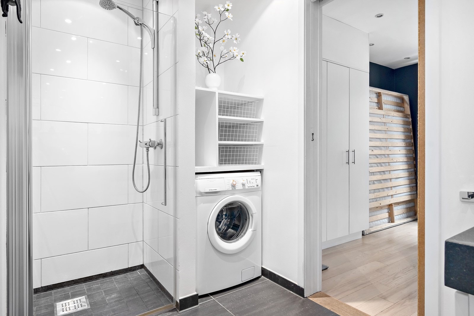 Badet består av flislagt gulv med varmekabler, flislagte vegger og malt himling med spotter. Opplegg for vaskemaskin. Galleribilde